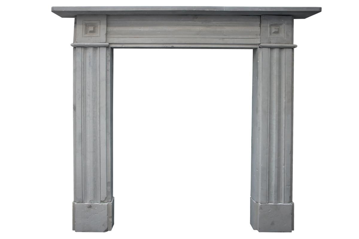 Antique early 19th century Regency carved stone fireplace surround from solid grey York stone. Fluted legs terminate in carved square capitals, circa 1820. 

Photographed with a free standing fire basket, sold separately.