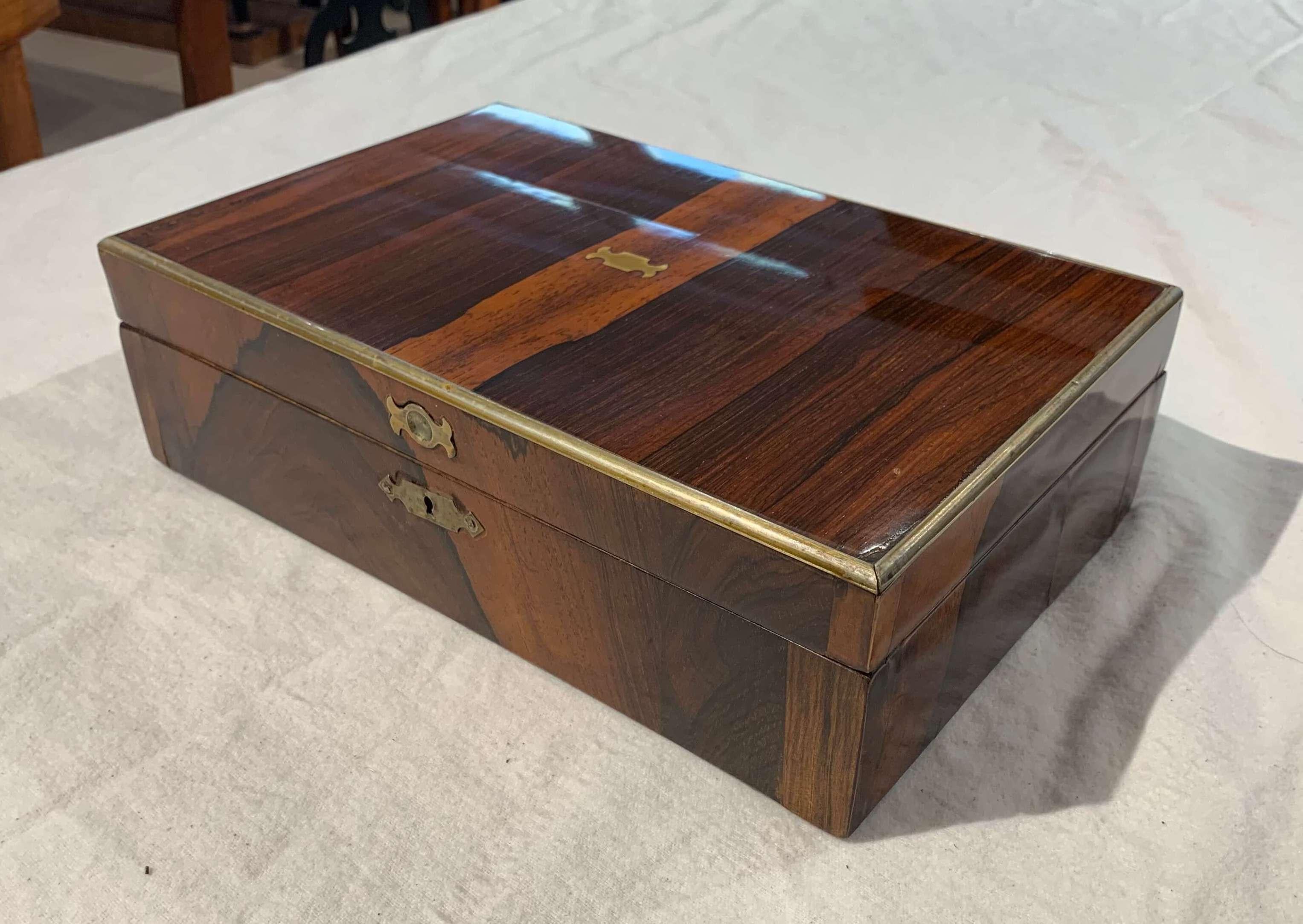 Neoclassical Biedermeie box, rosewood veneer, brass inlays, England, circa 1830

Beautiful rosewood/palisander veneered, French polished. Brass trims around the upper edge and brass fittings. Inside softwood (Spruce) painted.