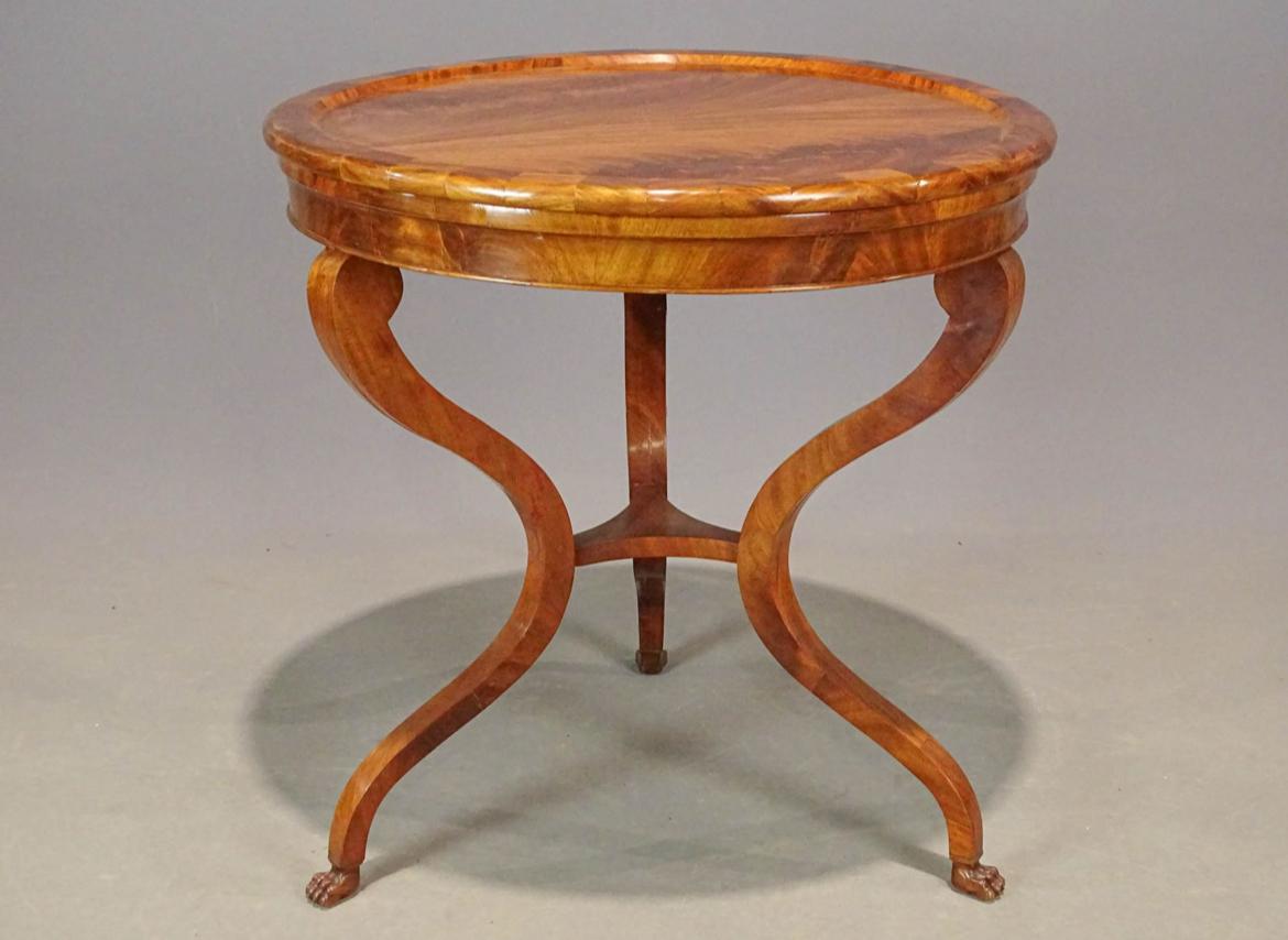 Elegante tavolino da centro o circolare in mogano a fiamma color miele, con piano svasato su una base a tre gambe con piedi a zampa intagliati, inglese, circa 1840. 