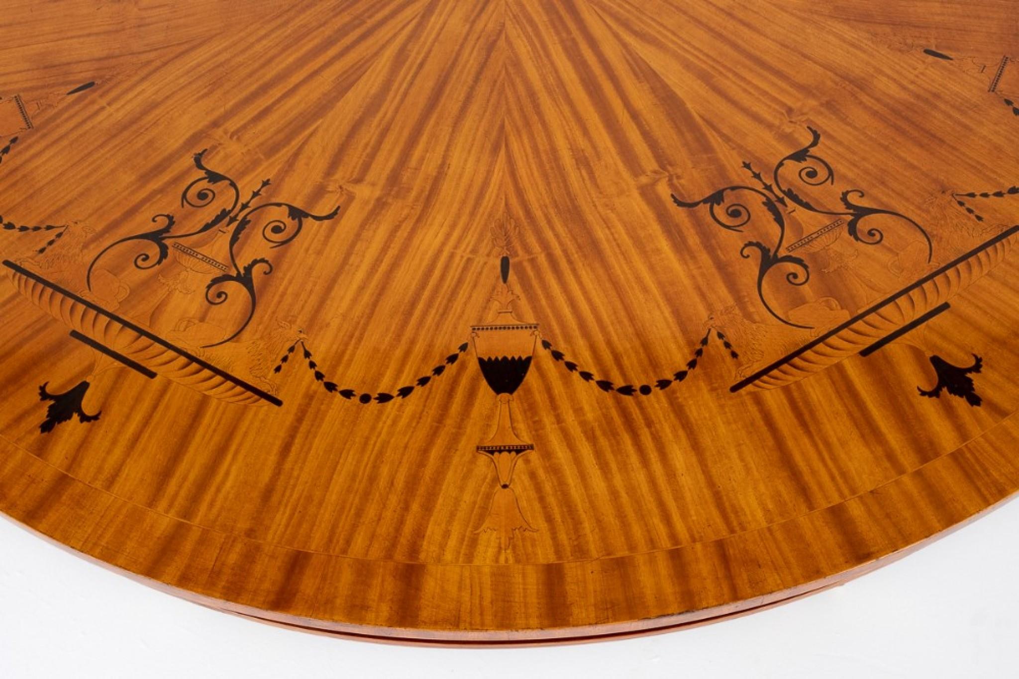 Regency Revival satinwood centre table.
circa 1900
The top of the table featuring segmented satinwood veneers with stylised ebony and rosewood inlays.
The base of the table featuring satinwood swept legs with rosewood crossbanding with brass box