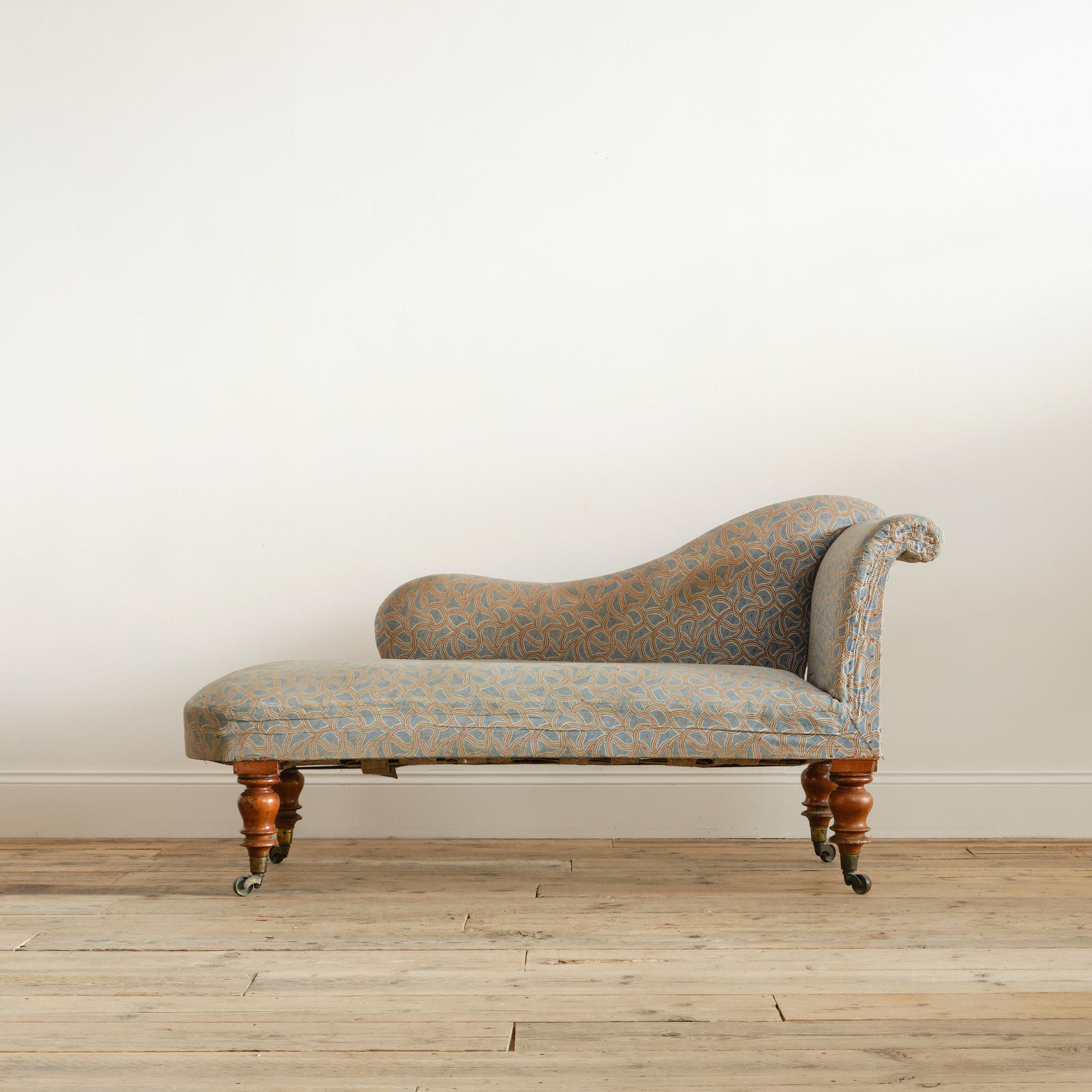 A well drawn English Regency chaise longue in its original vibrant printed linen cover. Raised on 4 tall turned walnut legs with the original brass cup casters. c1830

Structurally in good solid order with a remarkably well preserved frame which