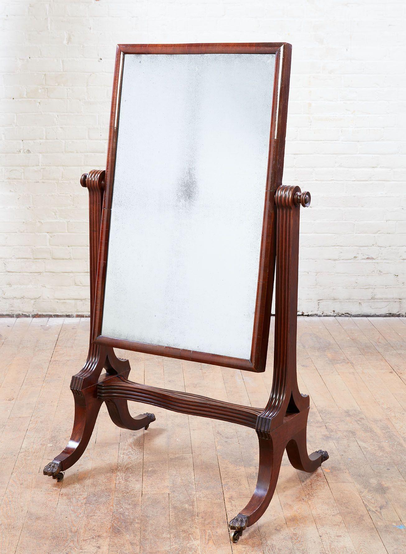 Fine English early 19th century mahogany cheval mirror, the original mercury glass plate with half round molded cross-grained frame, suspended from ribbed supports and standing on saber legs ending in paw feet, the whole possessing good rich color