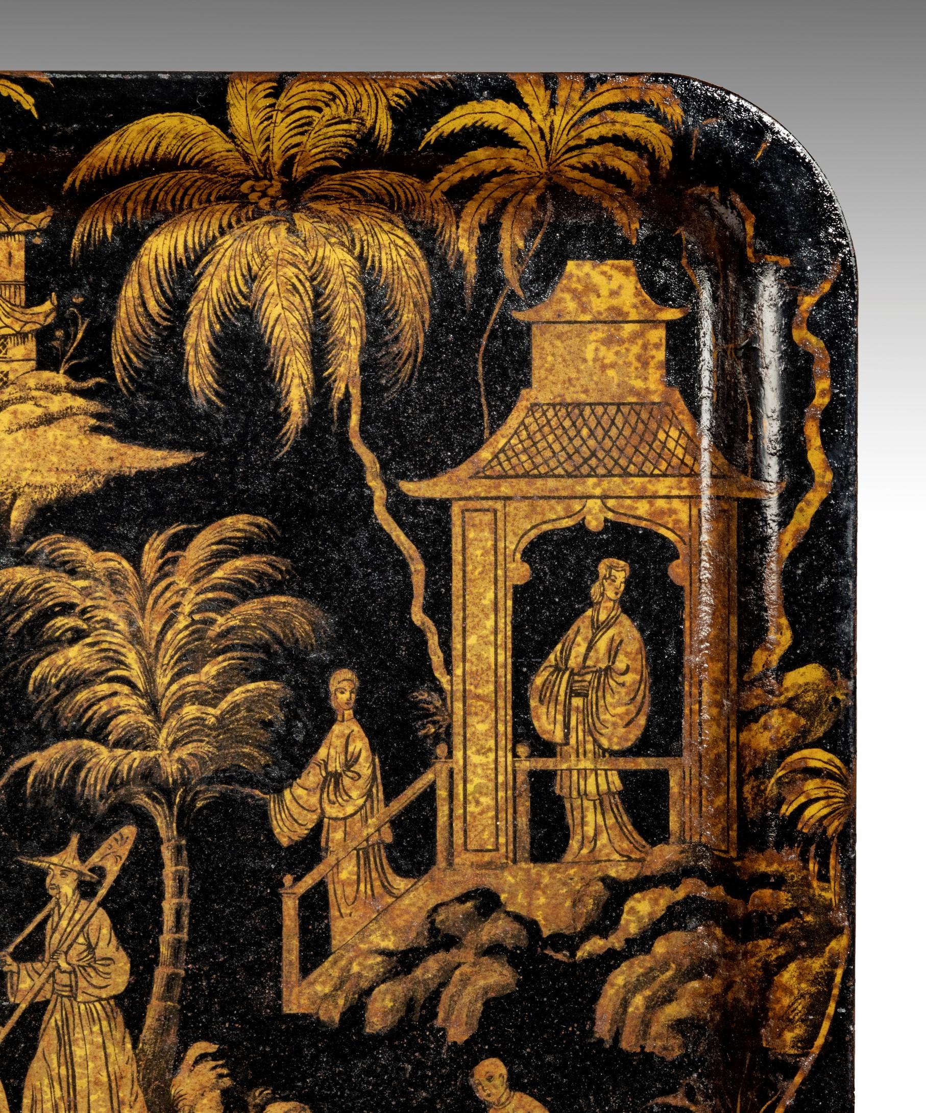 A highly decorative Regency period chinoiserie tray decorated in black and gold toleware (painted tin). The front of the tray is covered in mythical Chinese landscapes with pagodas, palm trees, a bridge and various figures.