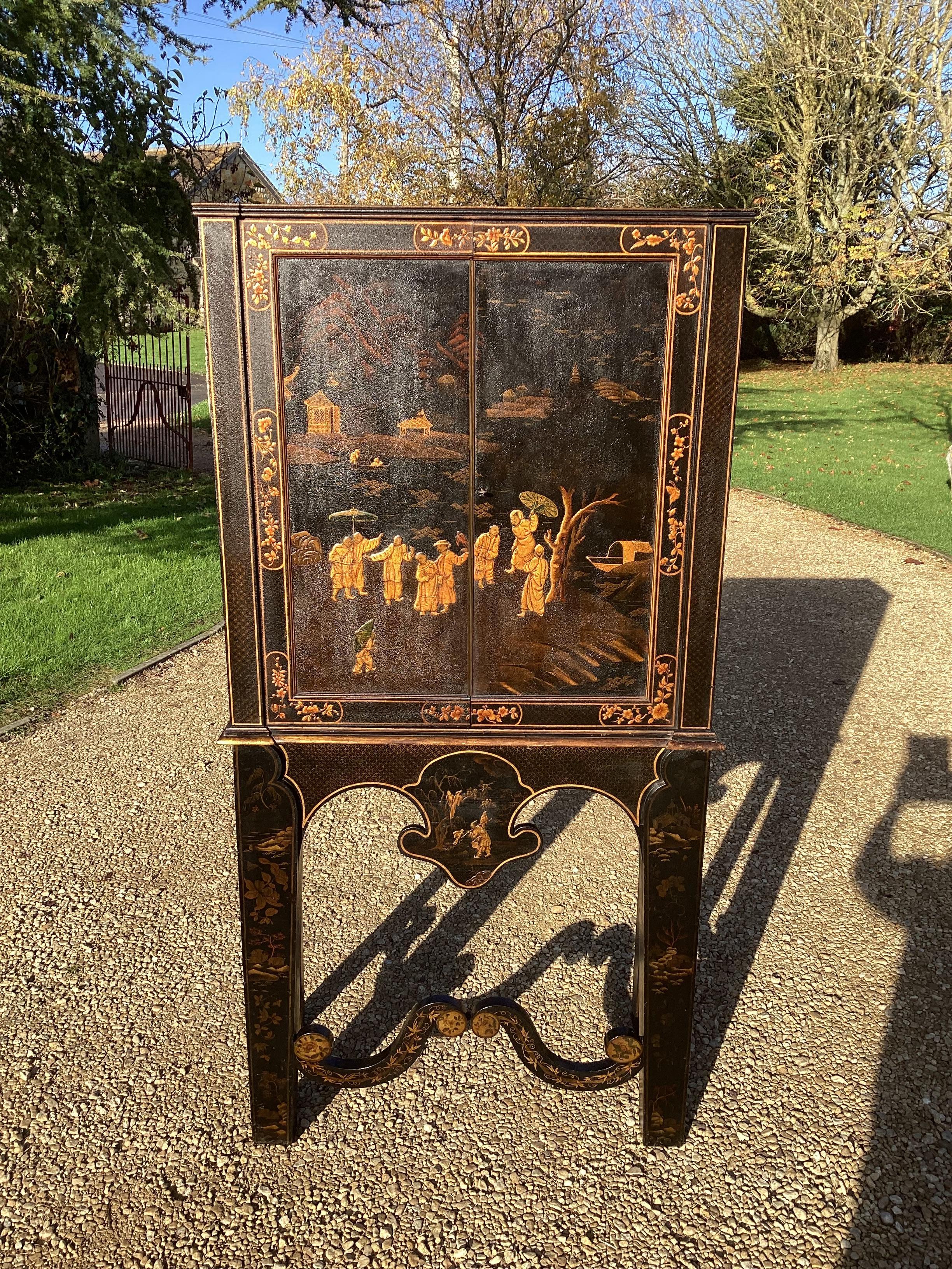 ﻿An important English Regency chinoiserie cabinet on stand, the cabinet with reeded top mould and inverted breakfront form, the doors decorated in high quality lacquer work depicting noble figures in traditional Chinese dress alongside trees, boats