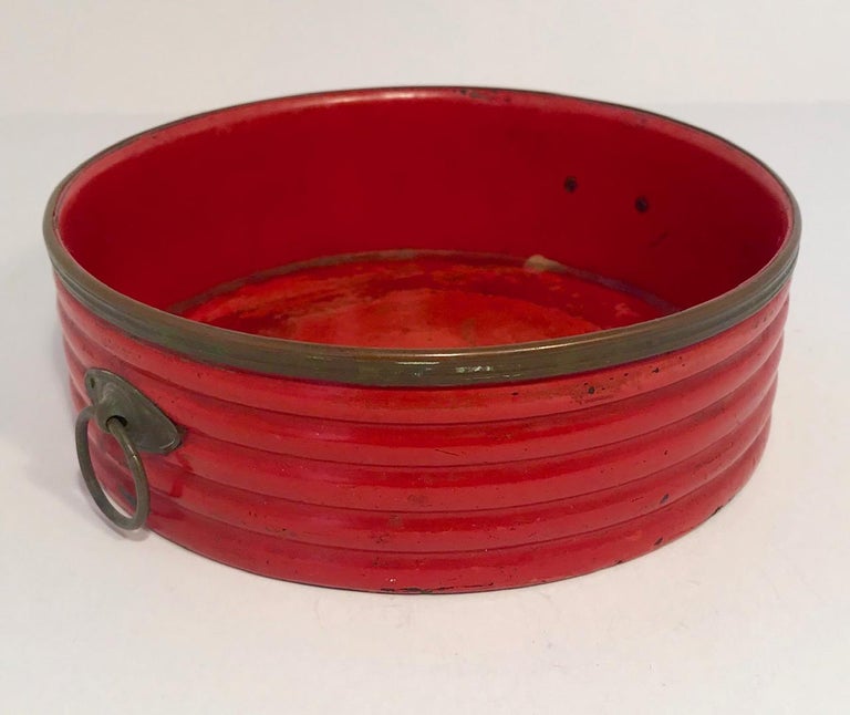 Period Regency cinnabar red lacquer coaster. The coaster was used to hold a wine bottle or decanter. The ribbed body is trimmed with Sheffield silver plate on the rim and navette shaped ring handles.  England, c. 1820

(This item is eligible for a