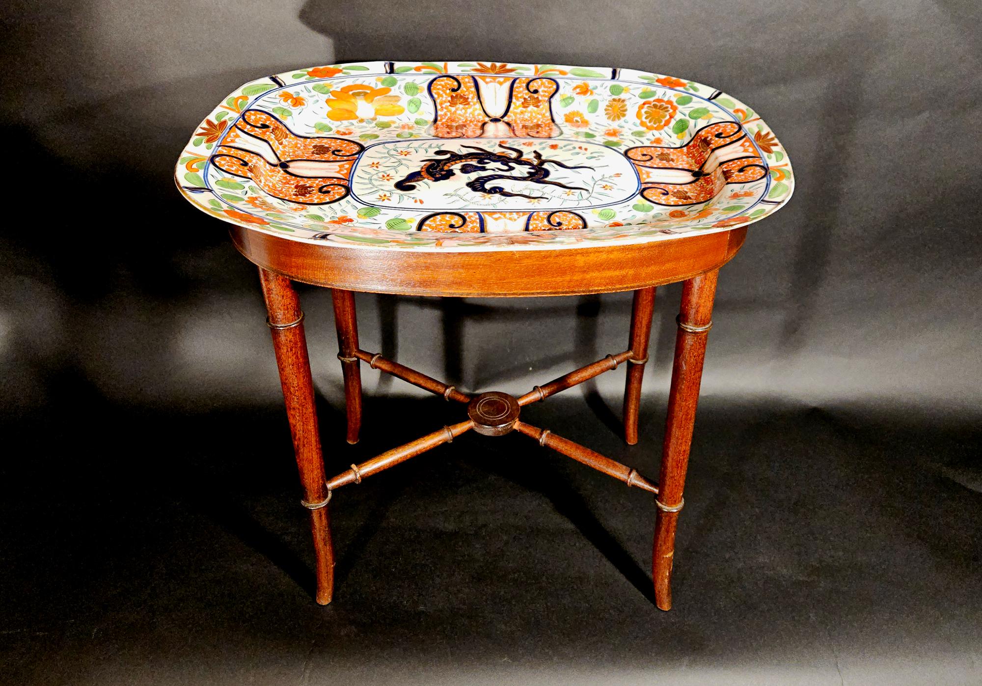 Regency Coalport “Imari Dragon” Porcelain Dish Mounted as Cocktail Table,
England, circa 1805–1815,
Porcelain with overglaze enamels; custom wood stand.

This monumental oval dish, transformed into a cocktail table with X-form spindle legs,