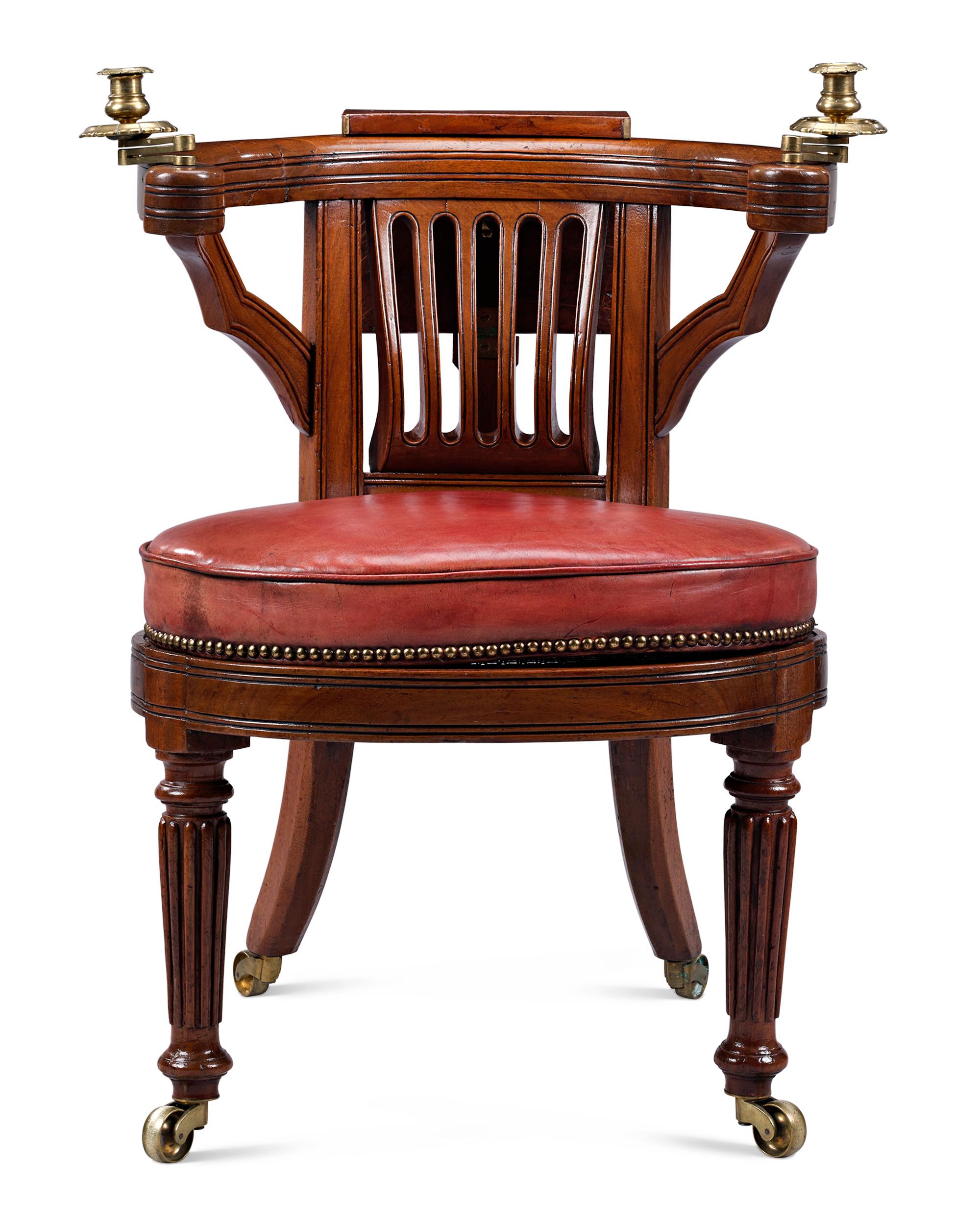 This rare Regency-period reading chair is stunning in both form and quality. Also known as a cockfighting chair, this intriguing leather-upholstered seat features a yoke-shaped top rail with an adjustable easel and a saddle seat. The unique shape