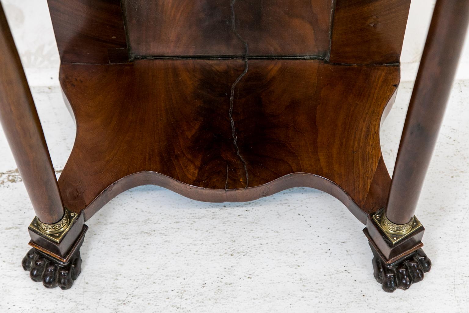 The top, apron, stiles and platform base of this Regency console side table are veneered and banded with crotch mahogany, with the turned columns having brass capitals and bases that terminate in carved claw feet, original mirror in base.