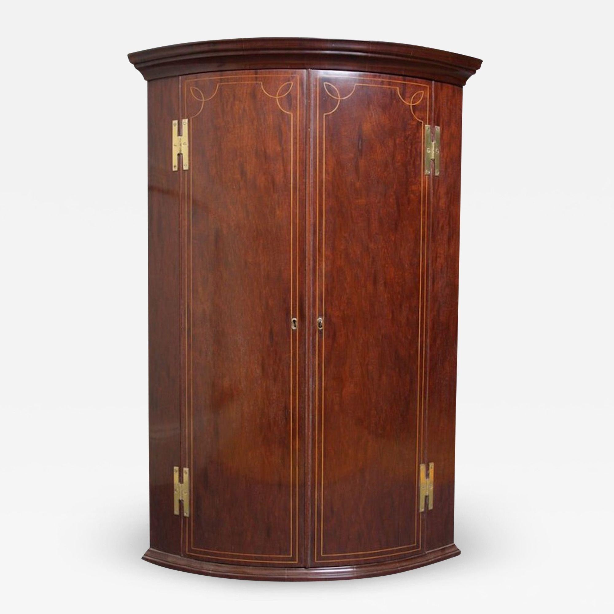 Sn630 Very attractive Regency, bowfronted corner cupboard, having moulded cornice, original, brass, H hinges and string inlaid doors enclosing 3 shelves and 3 spice drawers to base. All in wonderful condition, ready to place at home. circa
