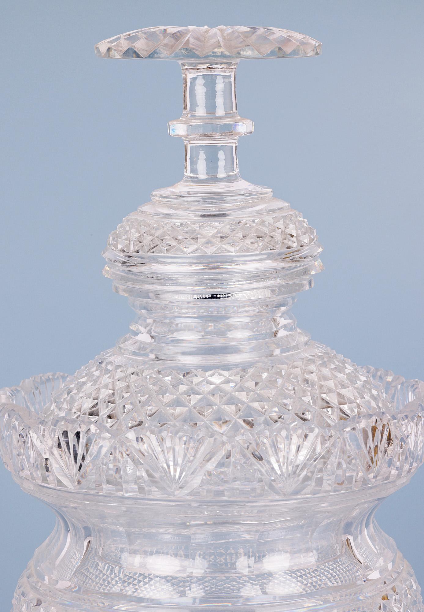 A very fine antique cut glass jar with matching cover dating from around 1825. The jar stands on a thick round star cut based foot with a round bulbous body with diamond and prism cut patterning with an ornate cut glass petal rim with a cover of