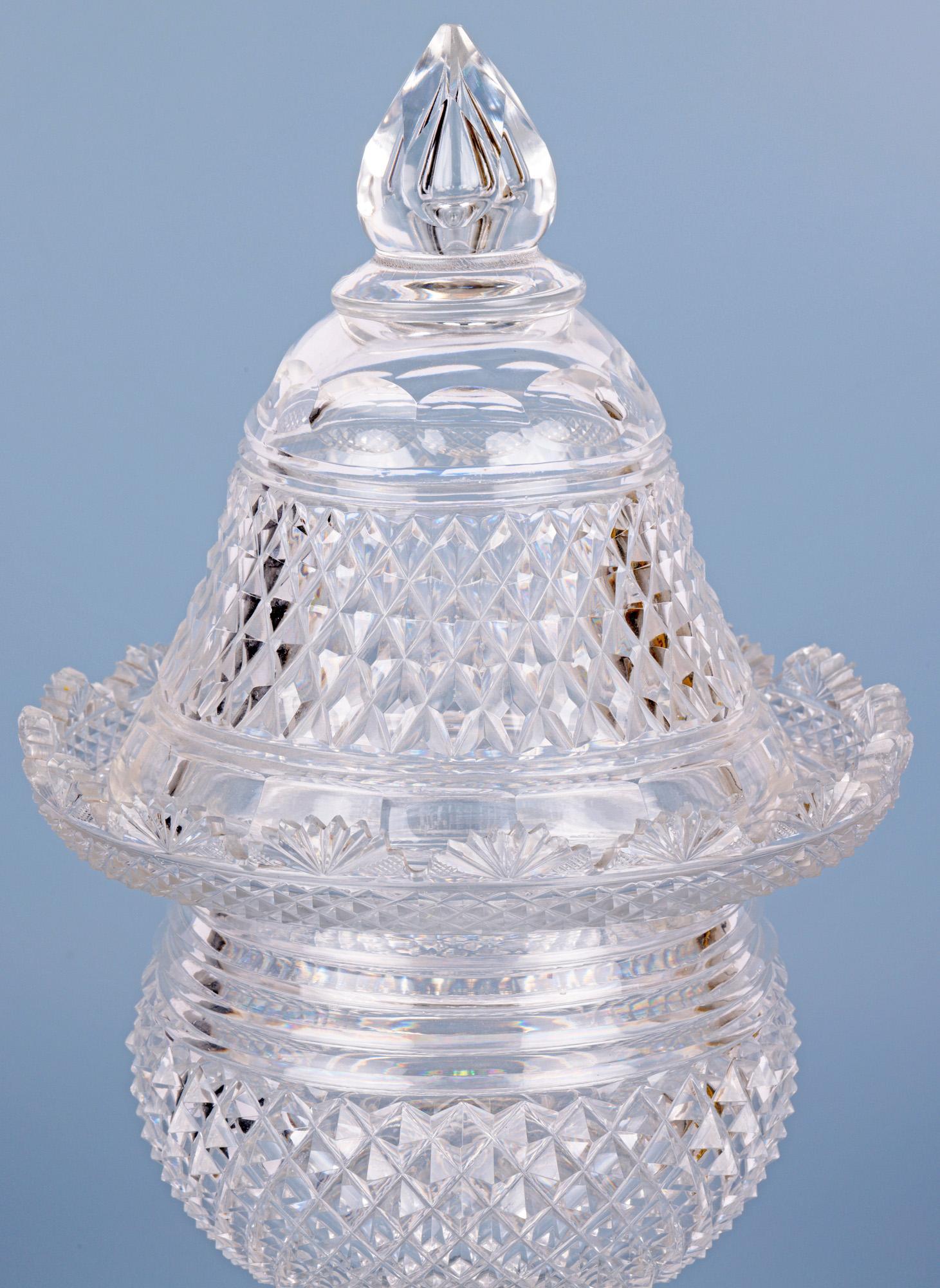 A very fine antique cut glass jar and matching cover dating from around 1825. The jar stands on a thick square star cut based foot with a narrow slice cut stem and round bulbous body with diamond and prism cut patterning with an ornate wide cut