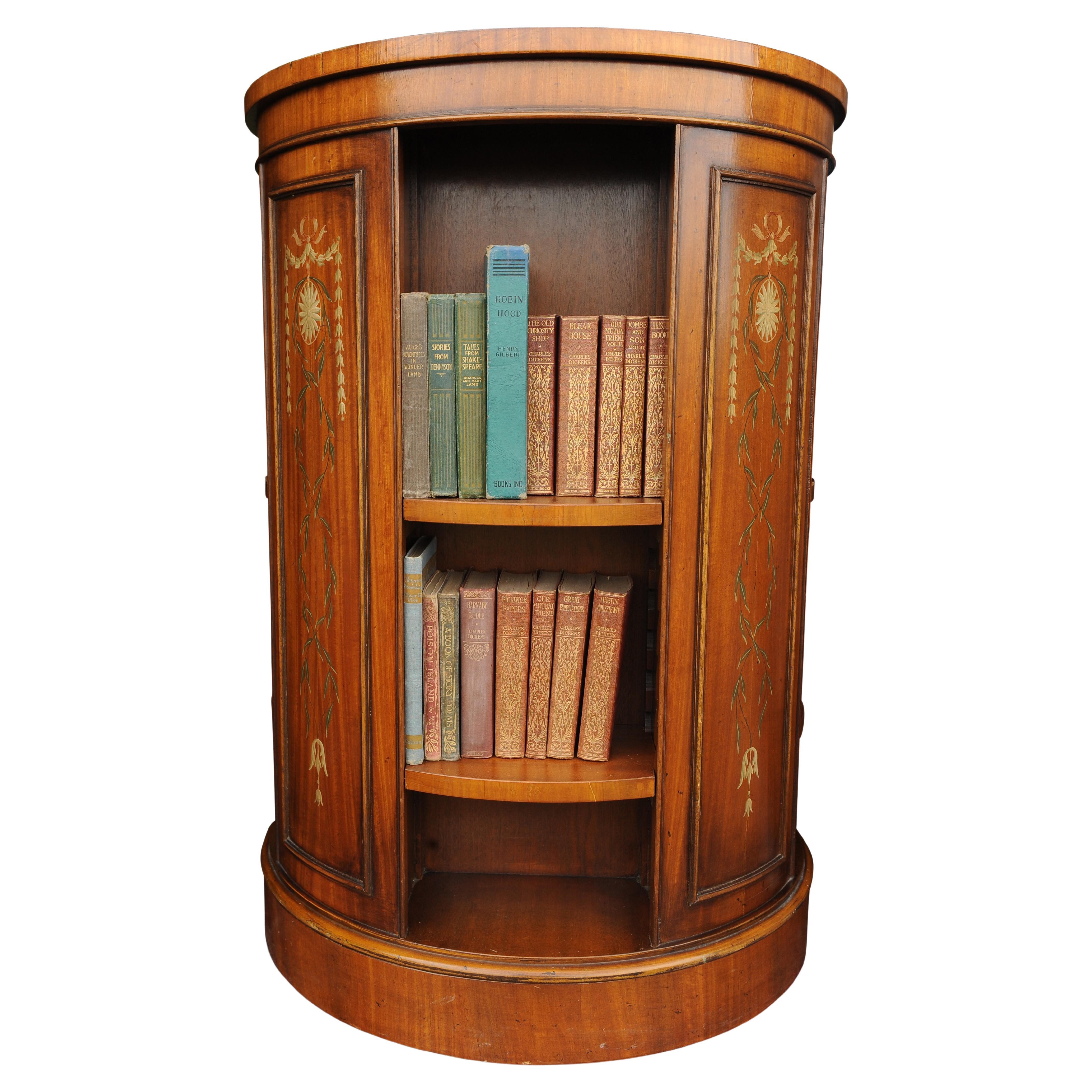 In The Manner of Robert Adam, A Revolving Drum Bookcase, 20th Century, the crossbanded top and side panels painted with floral and foliate festoons and musical instruments.

Very heavyweight well executed bookcase which revolves smoothly. 
All
