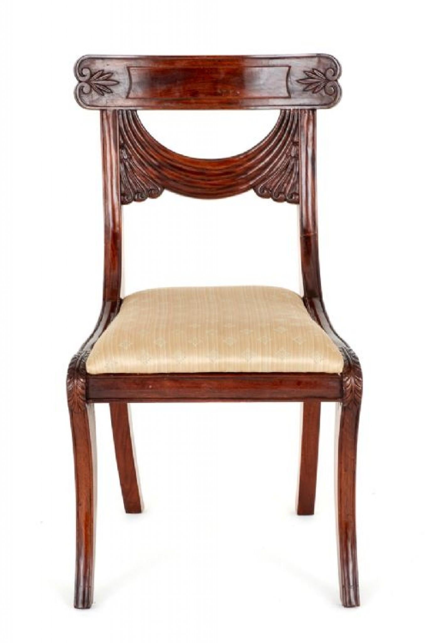 Set of 10 (8 + 2) mahogany regency style dining chairs.
These elegant dining chairs stand upon sabre front legs with swept back legs.
circa 1930
The seats being of a lift out form.
The backs of the chairs featuring a carved swag and drape.
The