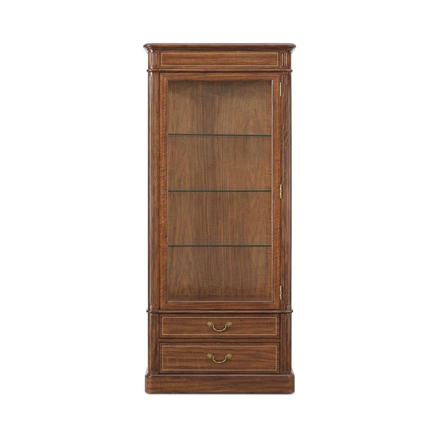 Drawing inspiration from classic Regency-era cabinetry, the piece is detailed with traditional reeded accents and finished with classic brass hardware and trim that elevates its refined character.

A glass door and side panels reveal adjustable