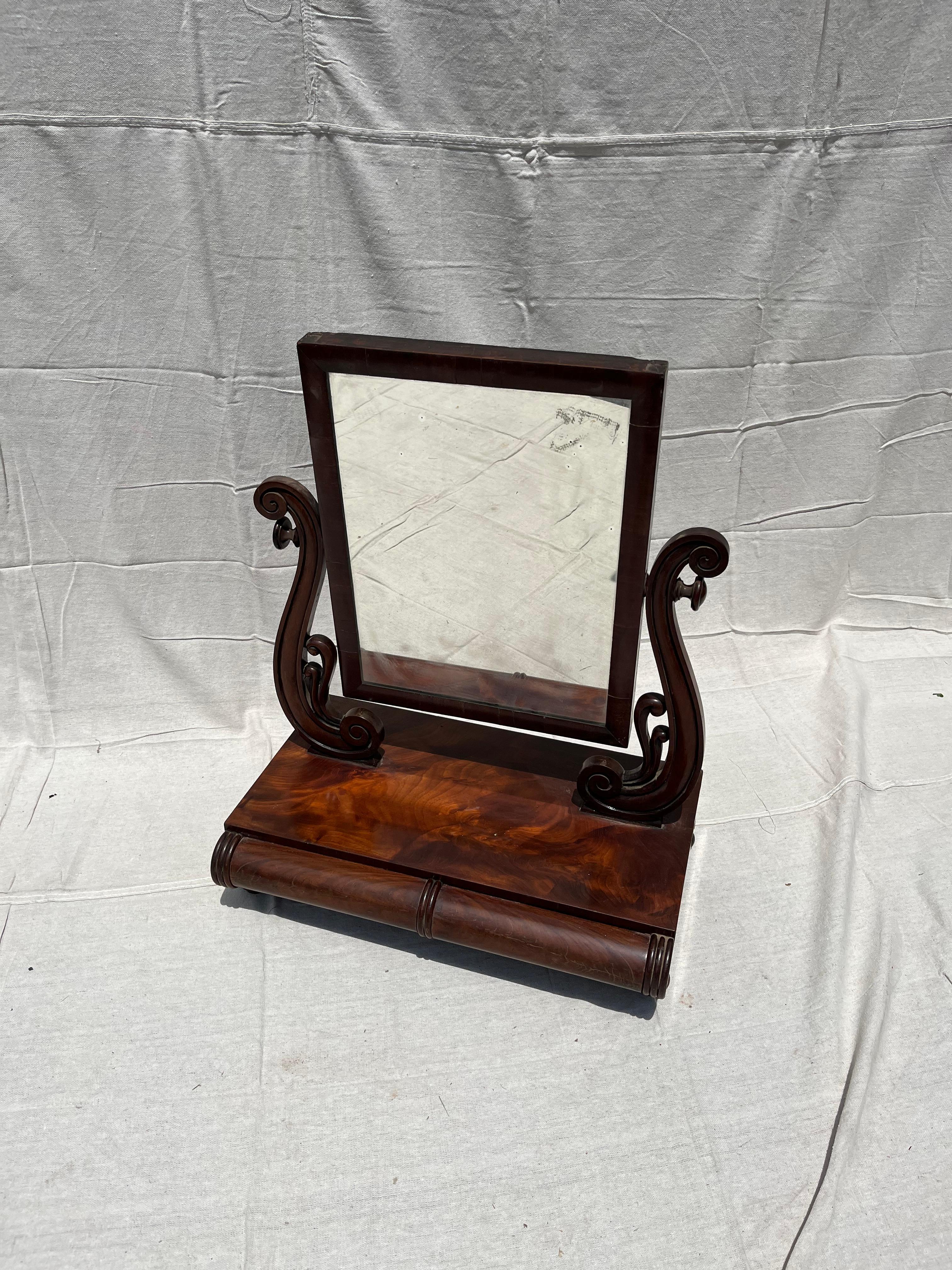 A Regency dressing mirror in figured mahogany with 2 small jewelry drawers and adjustable mirror.