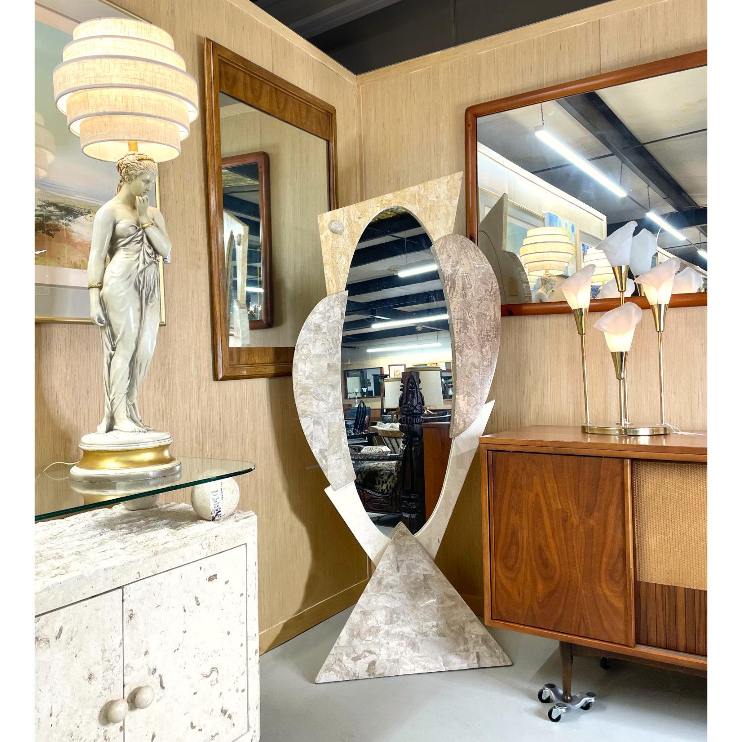 This pretty mirror is something fairy tales are made of. It boasts beautifully smooth and polished tessellated stone throughout and stands firmly on a stone carved pyramid. The multicolored stone and asymmetrical design give this piece a