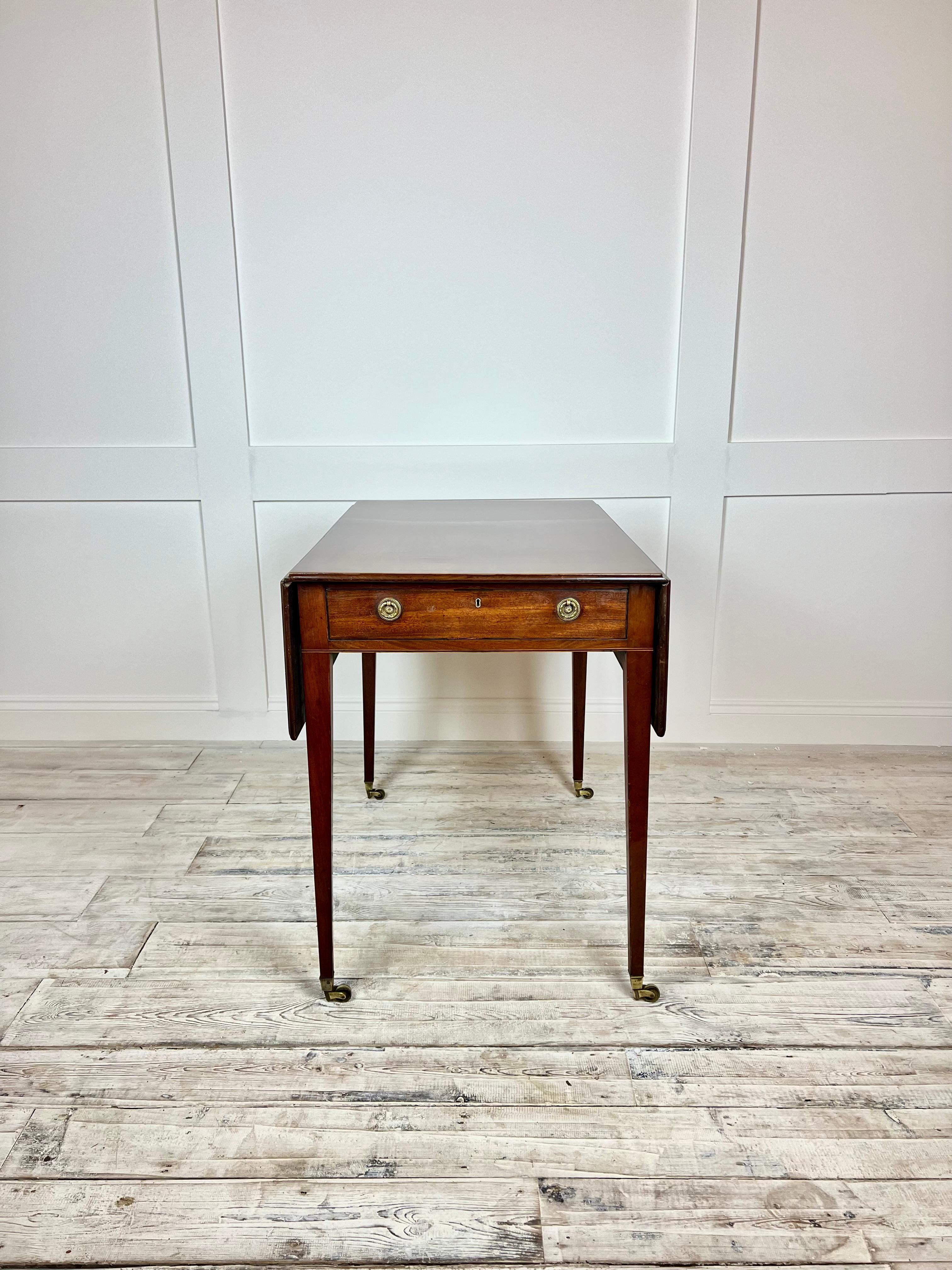 A delightful example of Regency drop leaf Mahogany table, dating back to the early 1800's. This table is crafted of a rich Mahogany and polished finish with elegant late Regency-style Tapering legs with original Brass castors. This table as a rich