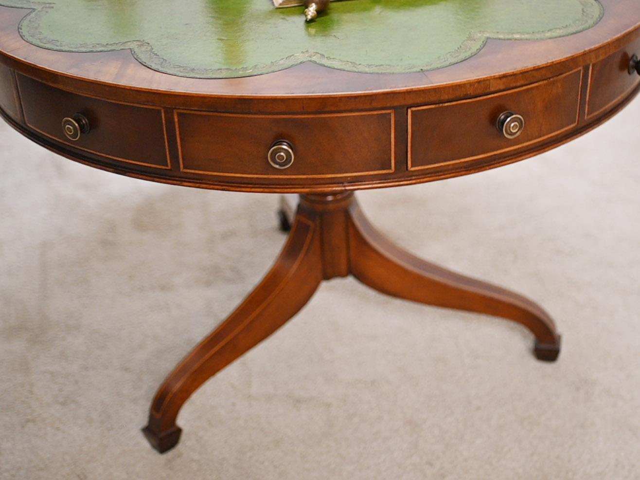 A circular Regency style drum table in mahogany with a tooled green leather scalloped top
Love how the leather sits on the table, almost like a clover afffect
The drawers each have marquetry inlay in satinwood on the edges
All with brass knob