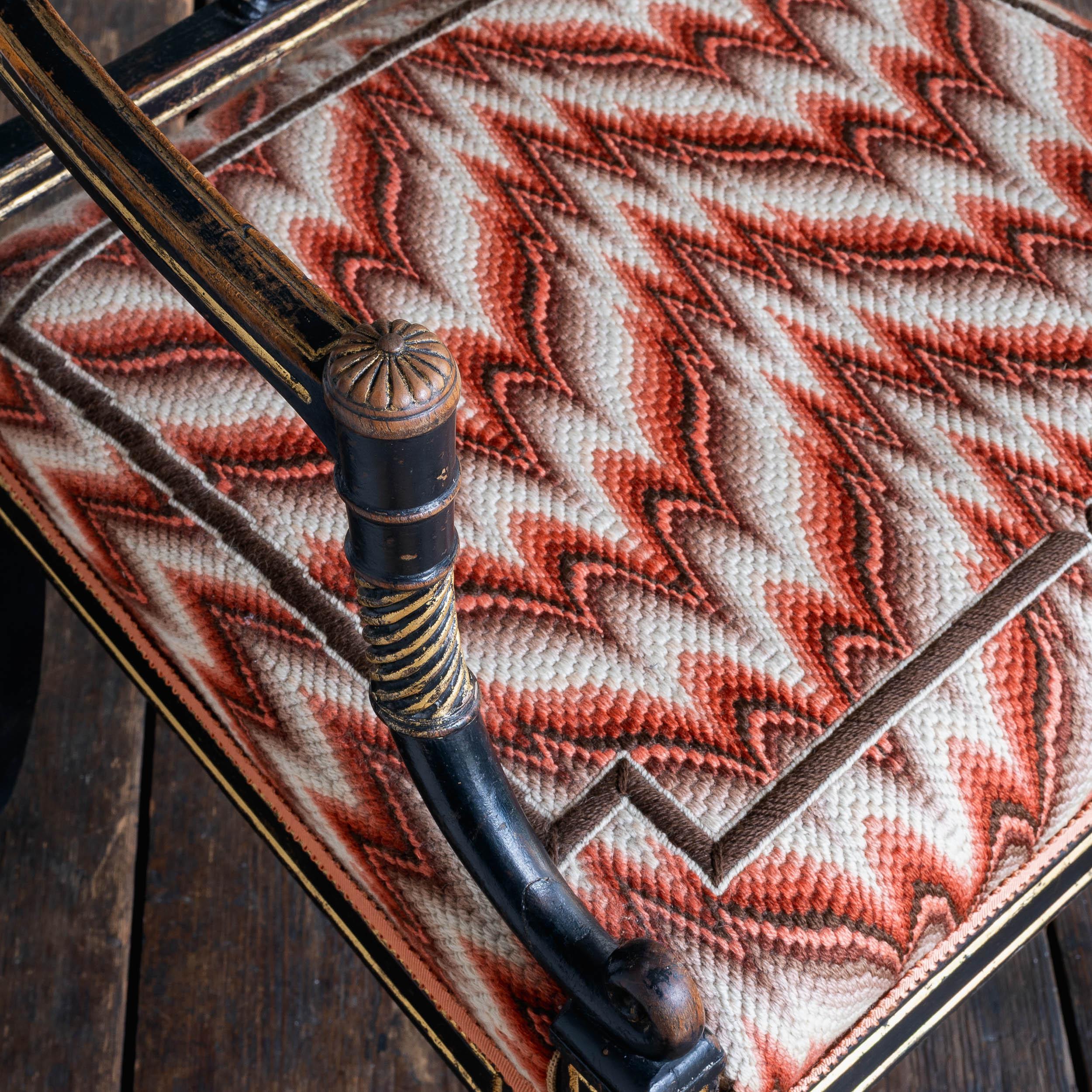 Ein ebonisierter und paketvergoldeter Regency-Sessel mit Lyra-Rückenlehne und Bargello-Polsterung mit Flammenstich.