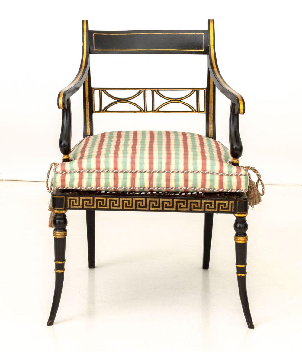 Regency Ebonized and Gilt Arm Chair, early 19th century, with cane paneled seat and gilded Greek key border, with custom upholstered cushion. 
33.75