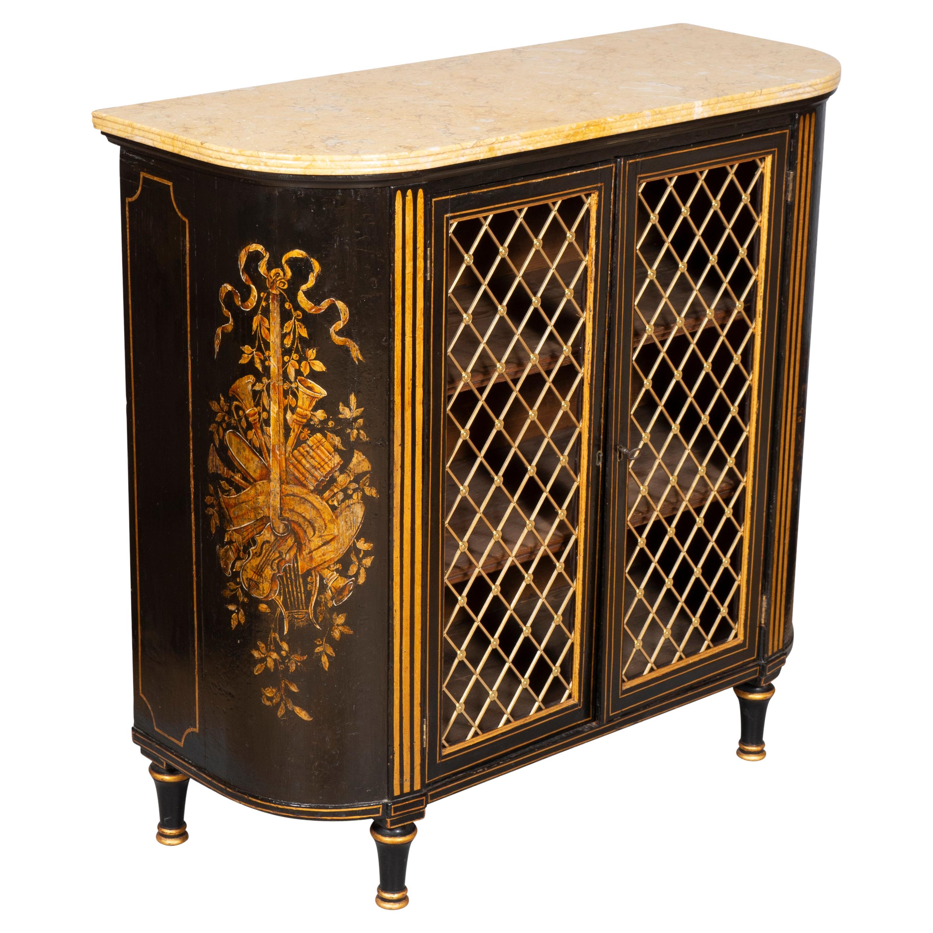 Elongated D shaped Sienna marble top with reeded edge over a conforming case with a pair of brass grill cabinet doors enclosing two shelves. The sides decorated with subtle gilded musical trophies. Ending on circular tapered legs.