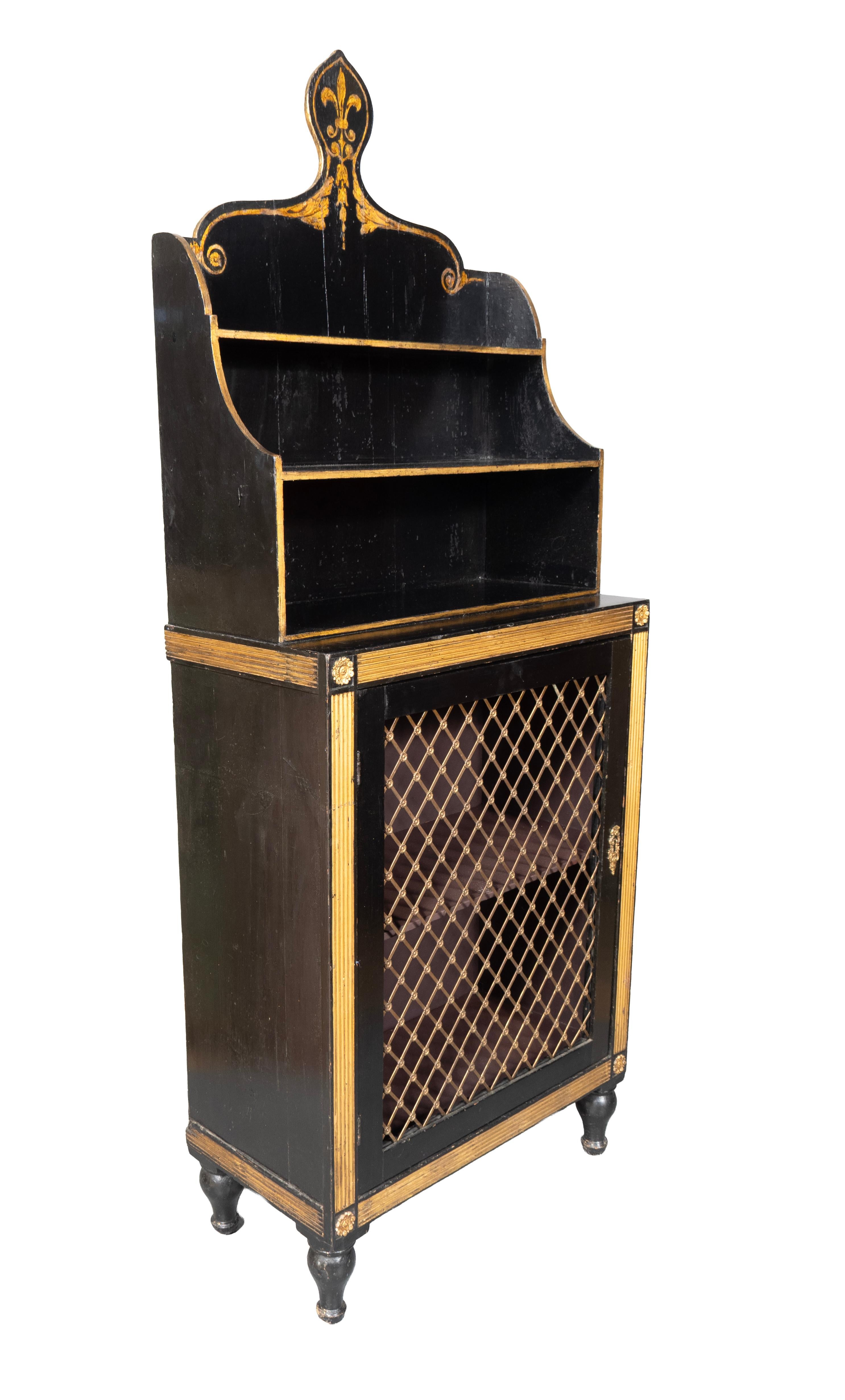 Lo stemma appuntito con fleur de lis stencilato sopra due mensole. La base ha un piano rettangolare sopra un'anta a griglia circondata da scanalature dorate che racchiudono un ripiano. Piedi di parrucchino torniti.