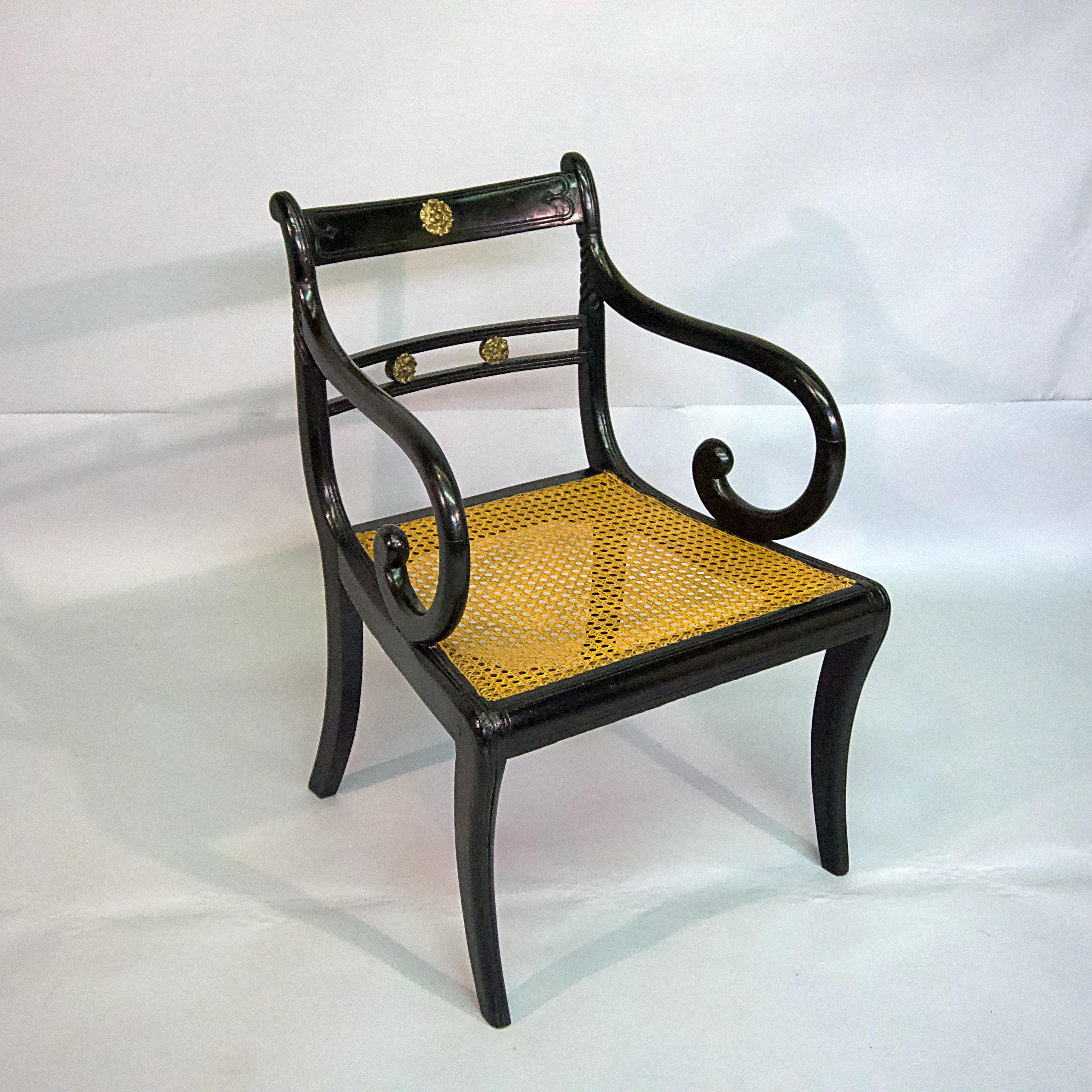 Regency ebonized caned armchair with brass accents.