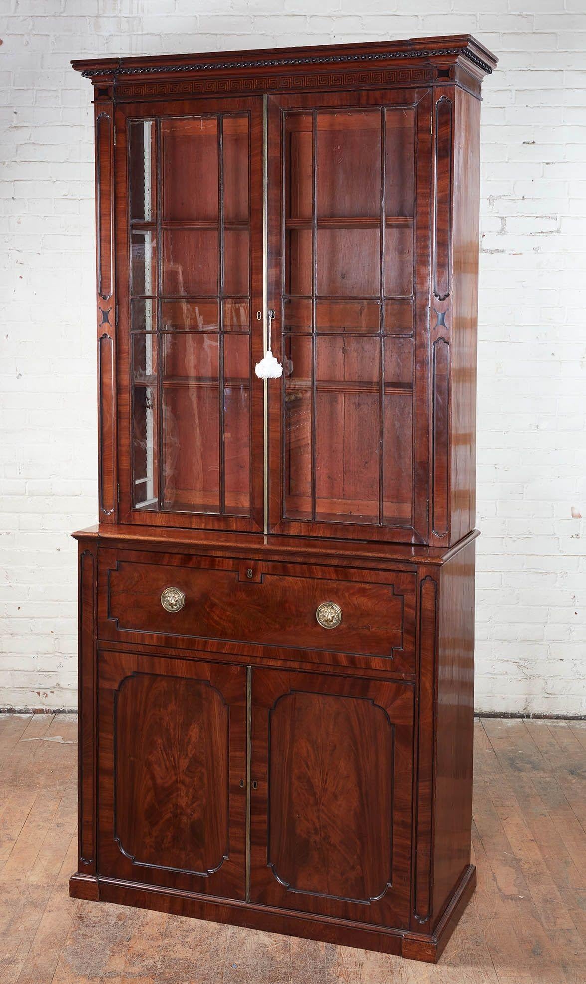 Very fine Regency period mahogany bookcase cabinet with secretary drawer, the molded cornice with ebonized ball drops over two astragal glazed doors over satinwood fitted pull out secretary drawer with original pull and with wonderful lion mask