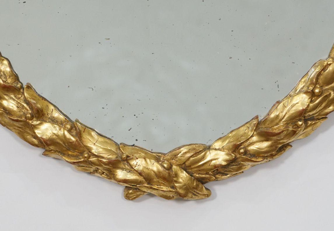 Verre Miroir ovale sculpté en bois doré de l'époque Régence avec motif de feuille de laurier d'Angleterre en vente