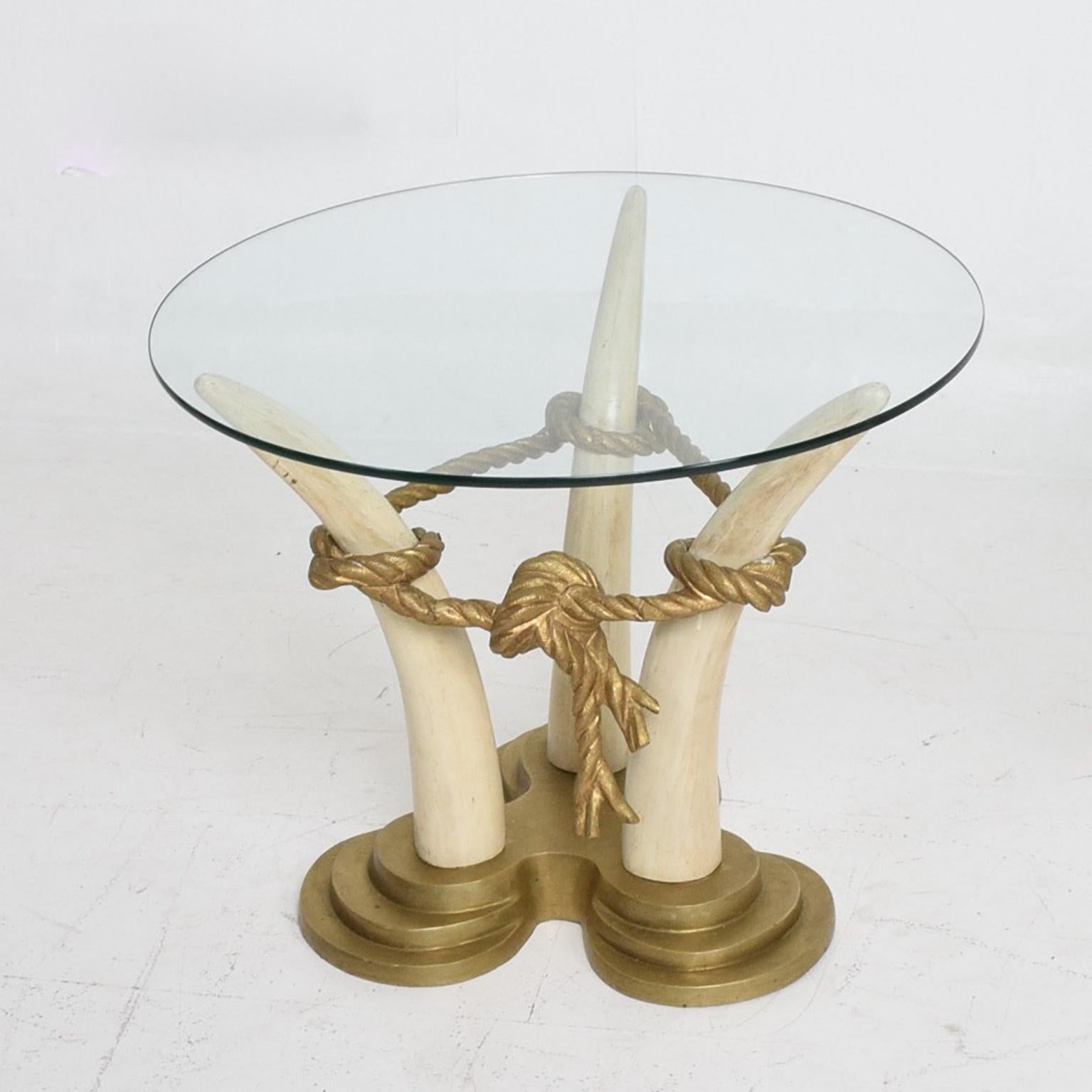 Side Tables
1970s by designer Italo Valenti of Spain VALENTI & CO 
Exotic side tables faux ivory bases made from painted hardwood.
Each faux tusk is connected by bronze rope and topped by a round glass panel that allows full view of the elaborate