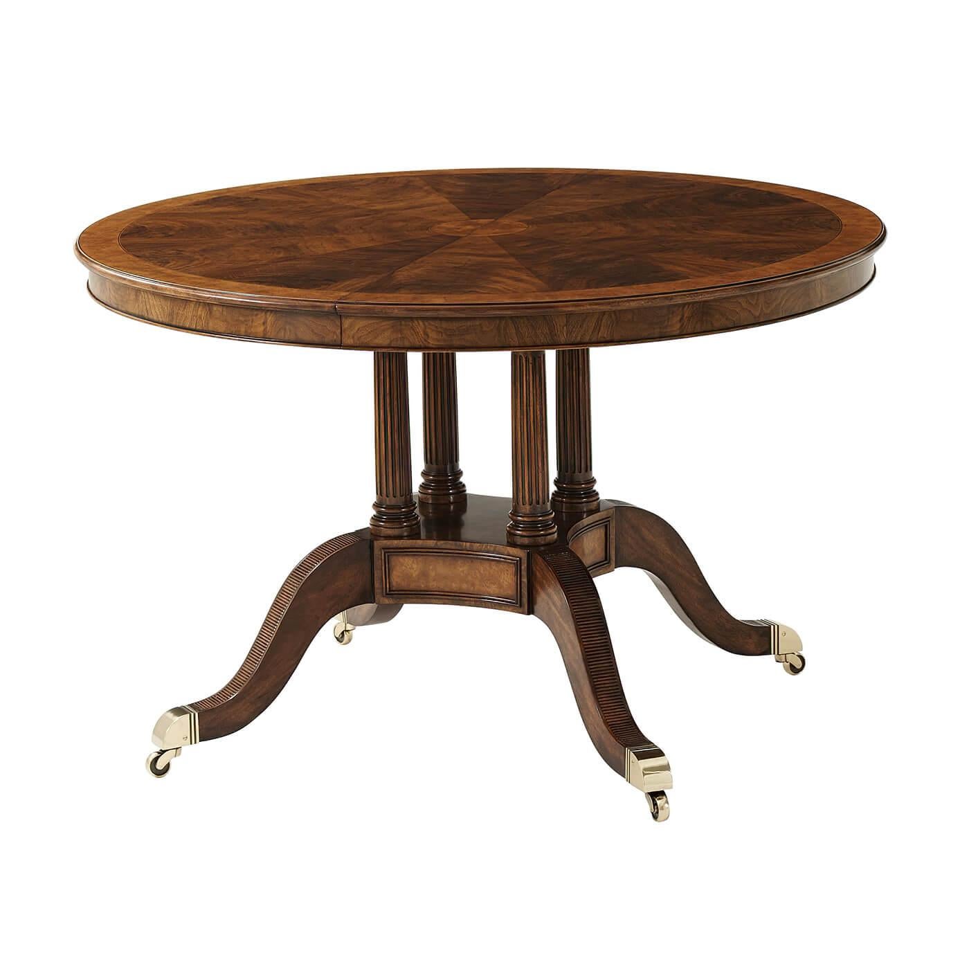 A fine extending walnut veneered and yew burl banded dining table, the circular top opening to accommodate an additional leaf and extending to a D end oval, on four turned and fluted column supports issuing from a plinth base with downswept mahogany