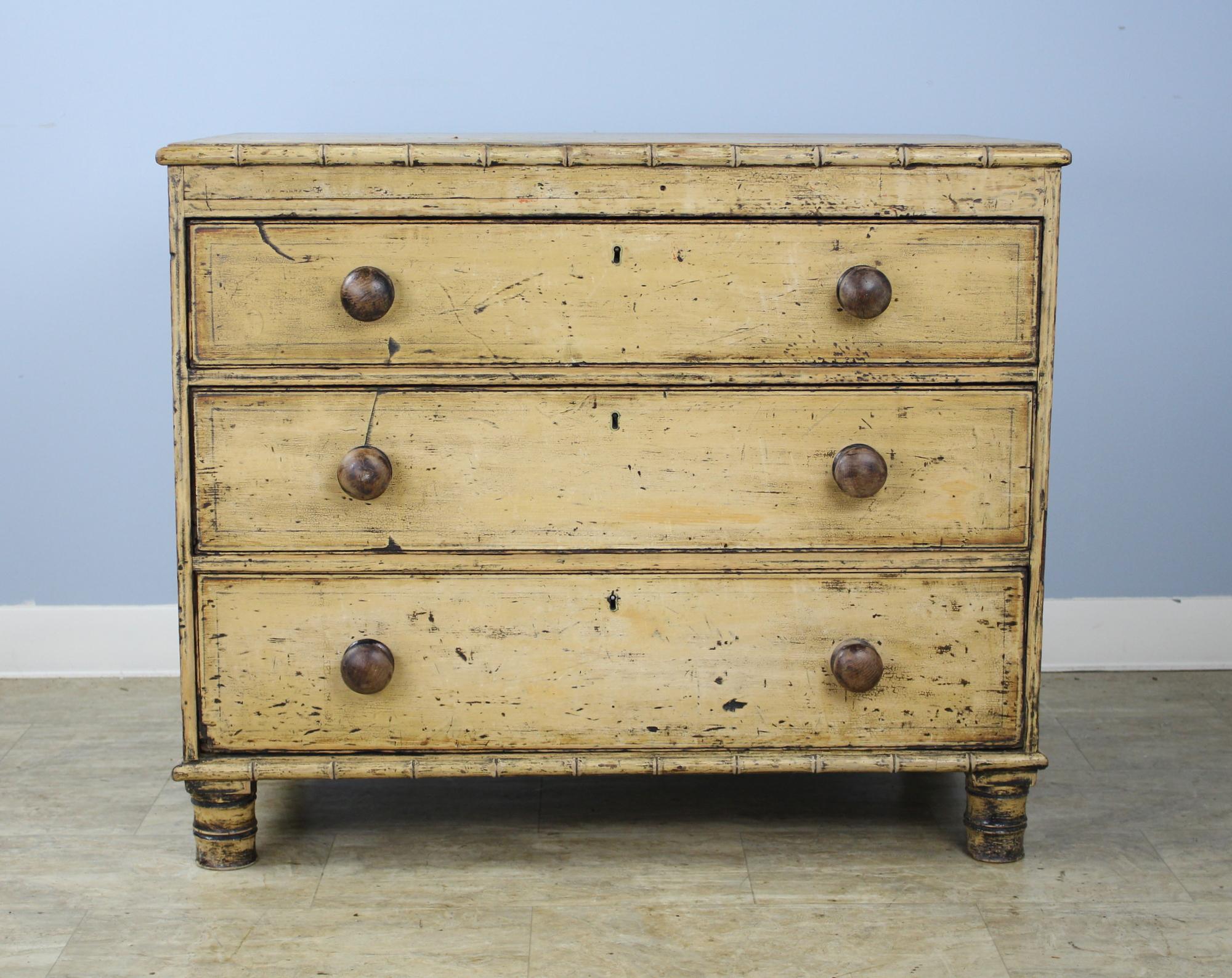 A small faux bamboo chest of drawers with wonderfully distressed original paint. The interiors of the three roomy drawers are remarkably clean for a piece of this age. We love the stylized feet and the dramatic distress. Great size for the guest