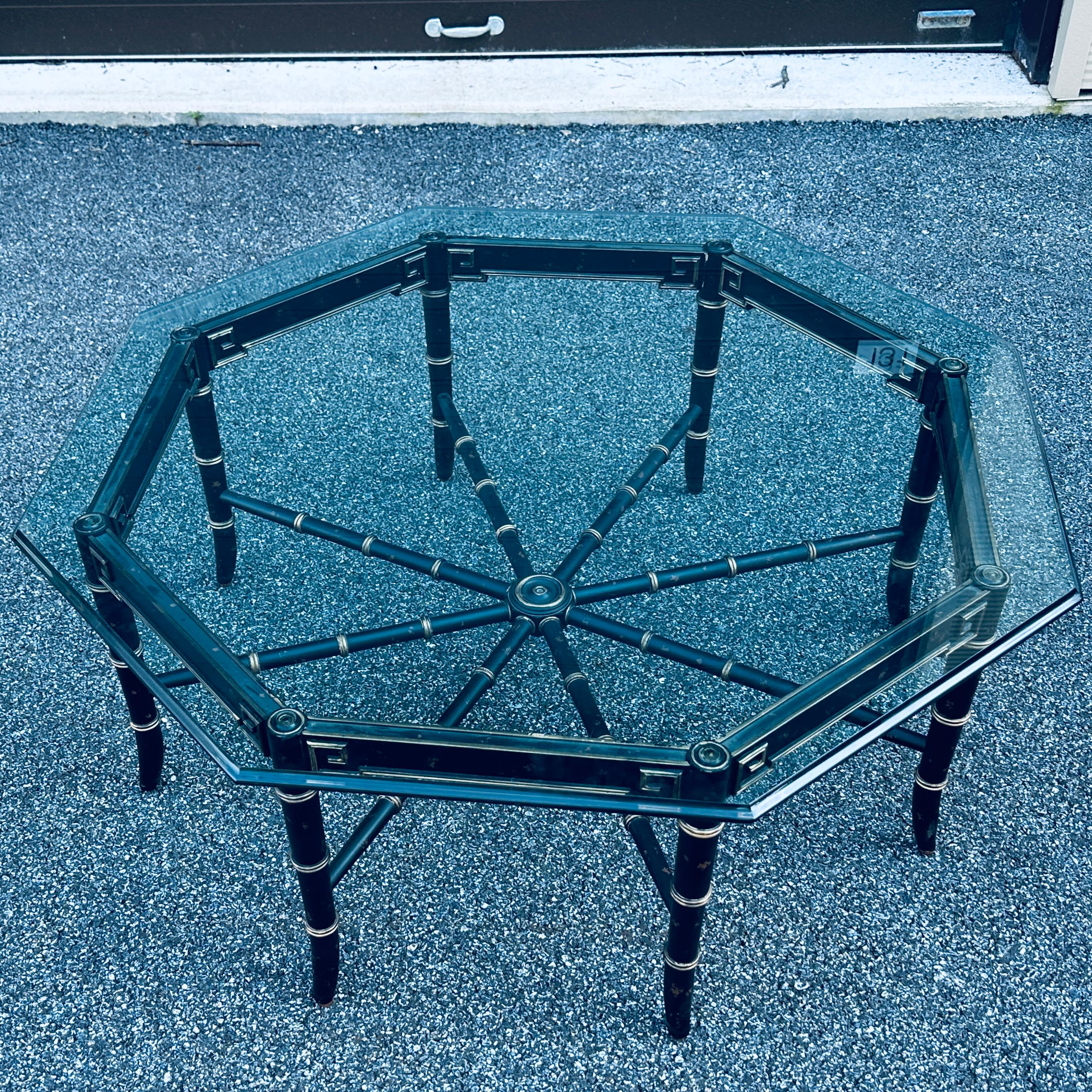 Regency style faux bamboo octagonal glass top cocktail table in a black and gold finish with intentional distressing throughout.
Base without glass measures roughly 38” x 38”