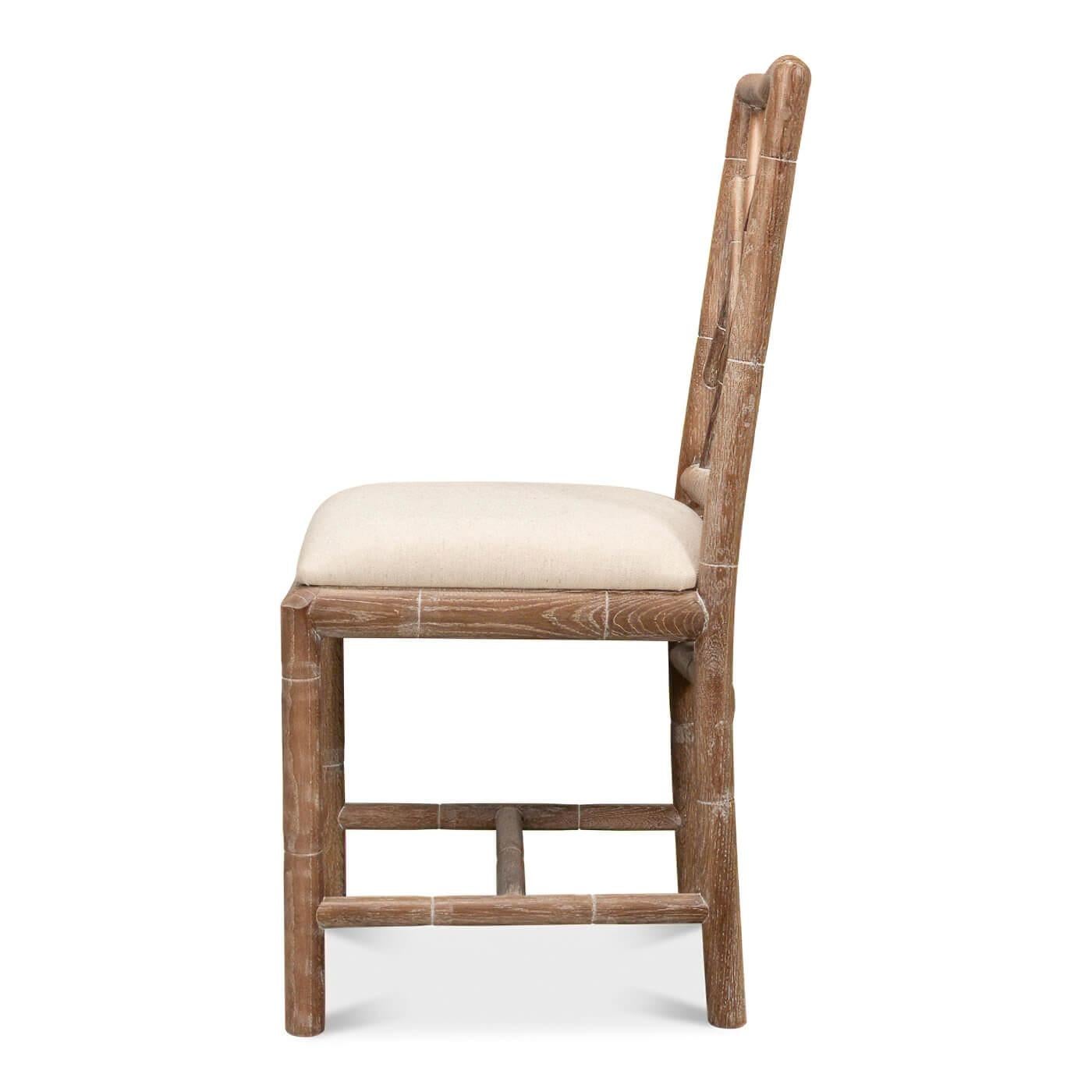 A Regency-style faux bamboo side chair. This hand-carved chair with a faux bamboo motif is inspired by designs of the Brighton Pavillion. It is shown in our whitewash oak finish with a linen seat. 

Dimensions: 17