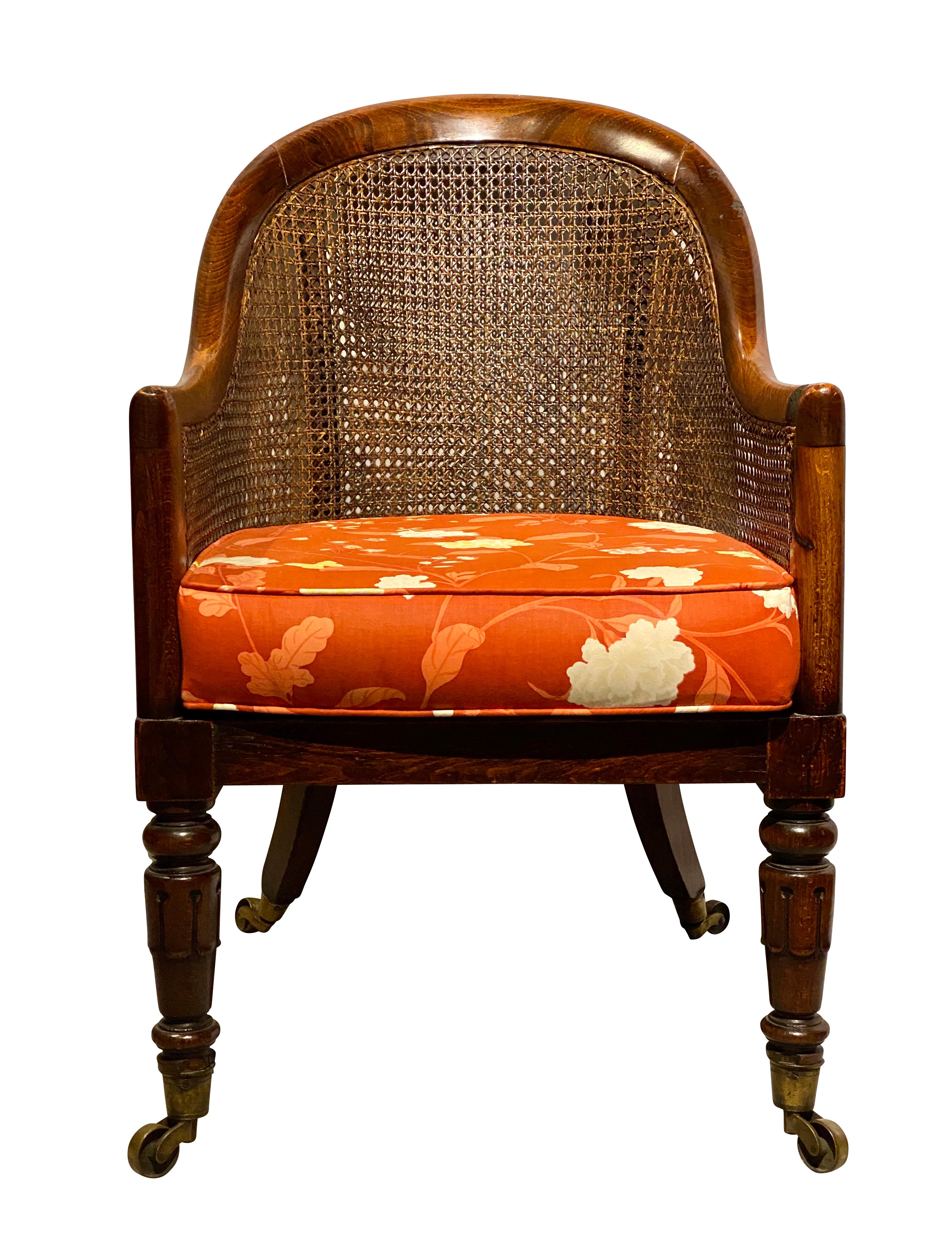 Arched rounded back and loose cushion seat raised on turned legs with casters.