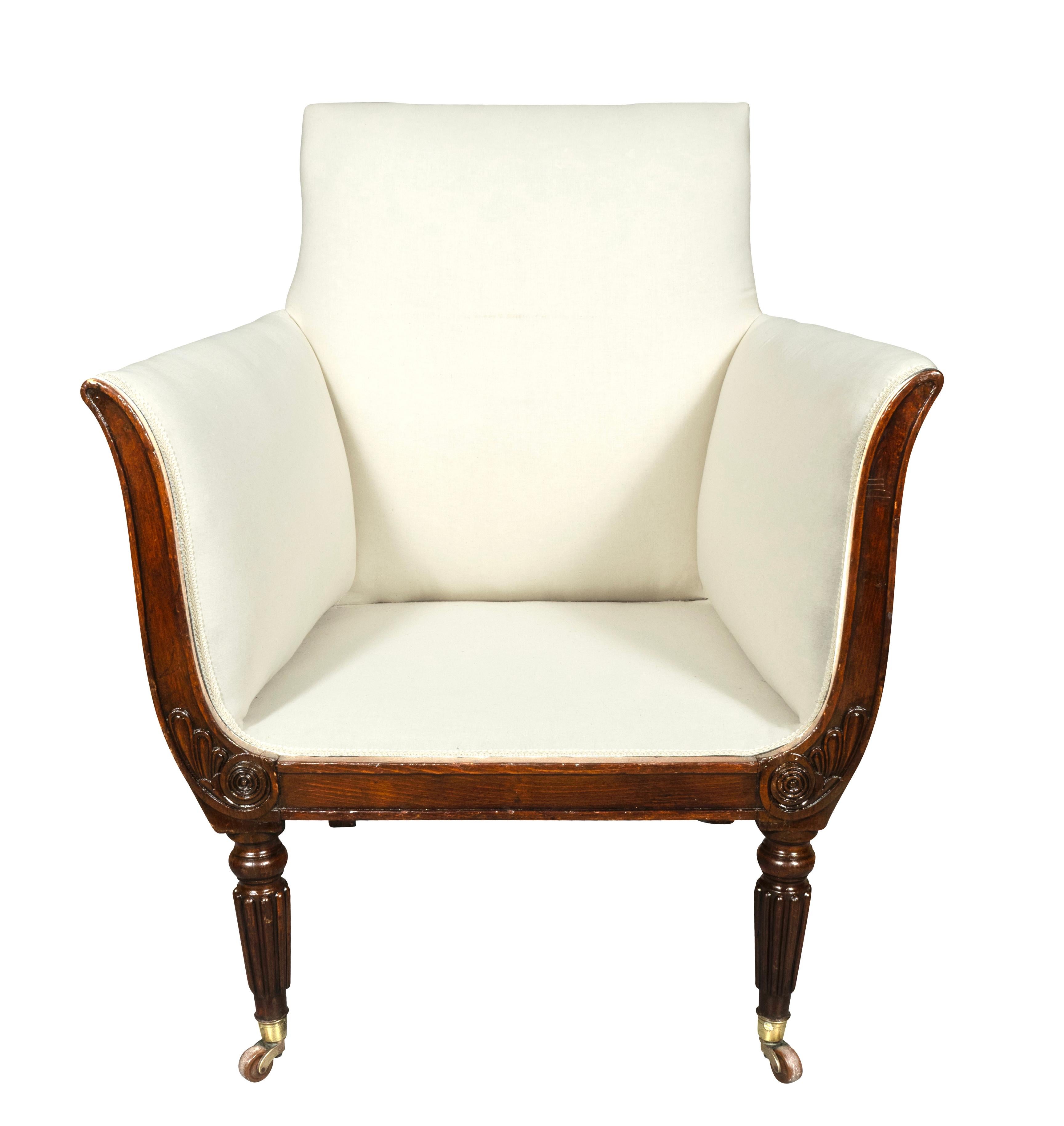Square newly upholstered back and sides and seat with loose cushion. Arms splay out. Turned tapered reeded legs with casters.