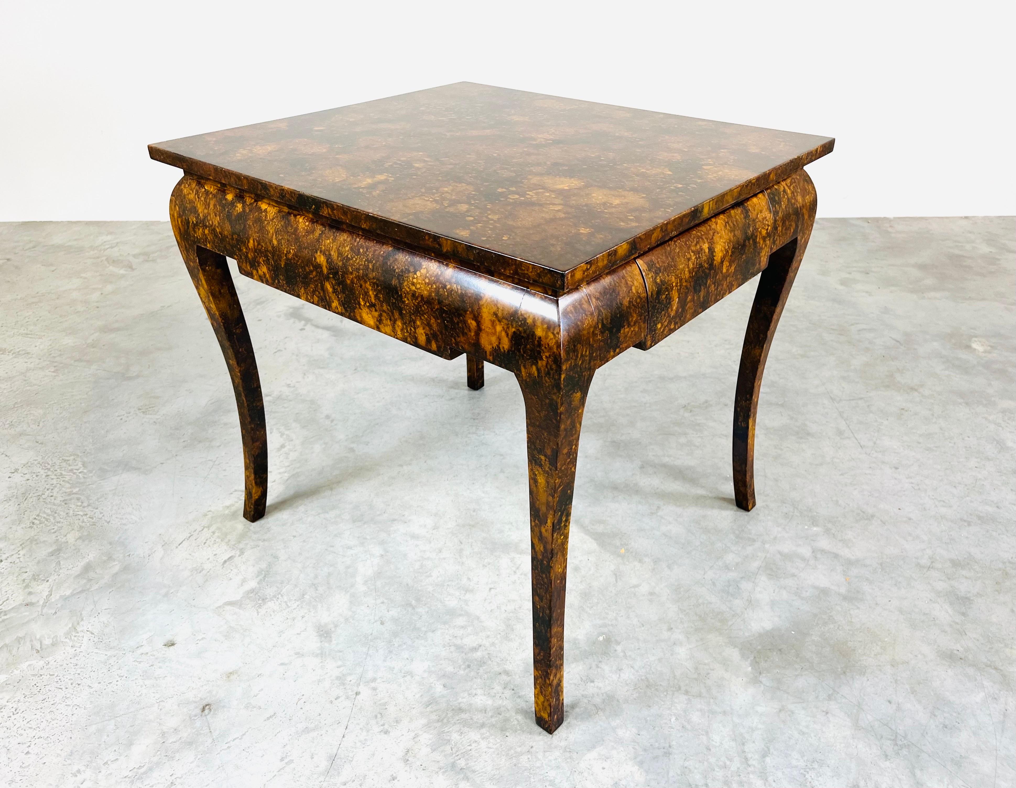 A vintage regency occasional table having faux tortoise finish having one slide out drawer for storage with sculptural legs and fantastic design. This is an eye-catching period piece that will ad character to the space in which it is added. 
