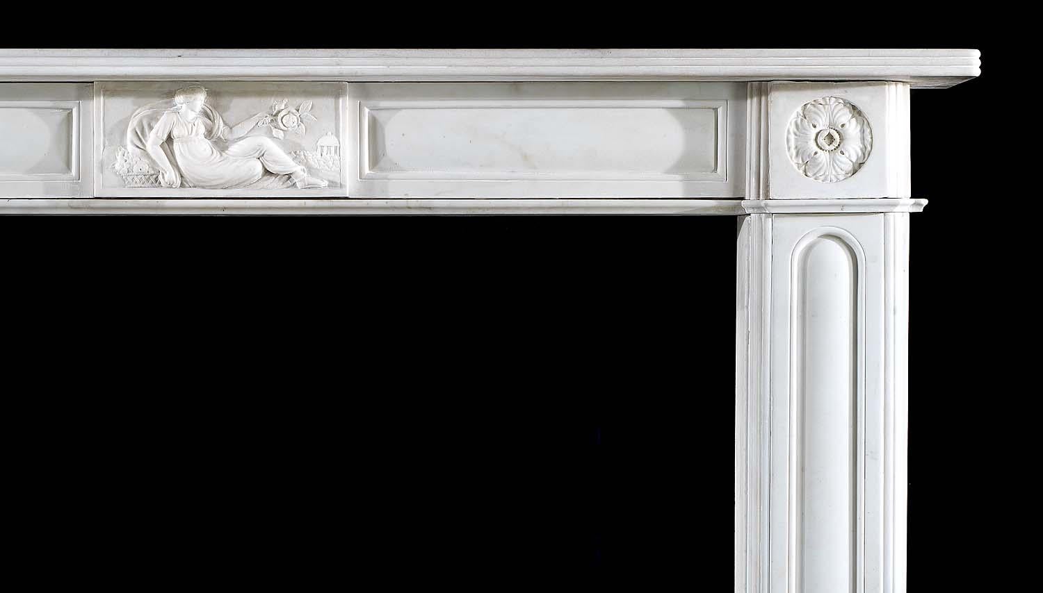 A fine Regency fireplace surround in pure white statuary marble. Beautifully elegant in its simplicity. The twin cushioned panelled frieze, beneath the moulded shelf, is centred by a tablet depicting a reclining Venus, holding aloft a rose, beside a