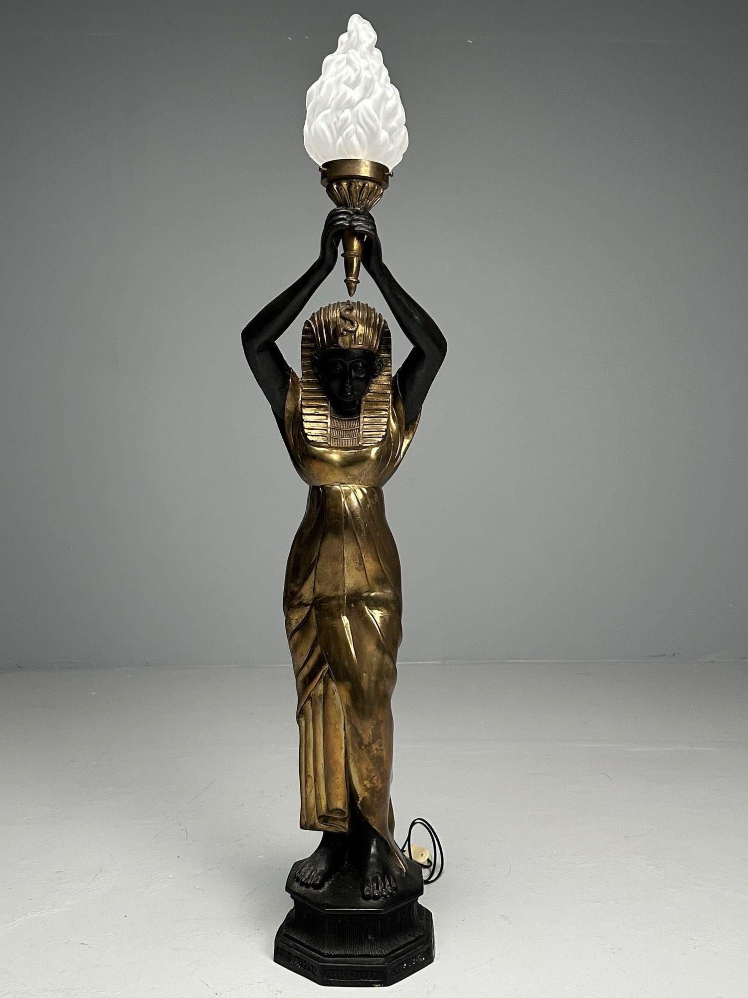 Regency Style Standing Lamp with Egyptian Motif, Gilt Metal, Bronze, 1990s

A stunning gilt metal and ebonize Nubian Egyptian goddess holding a Lalique style globe housing one light bulb. Wired.
Metal, Bronze, Glass
USA, 1990s

Height: 60.5 inches,