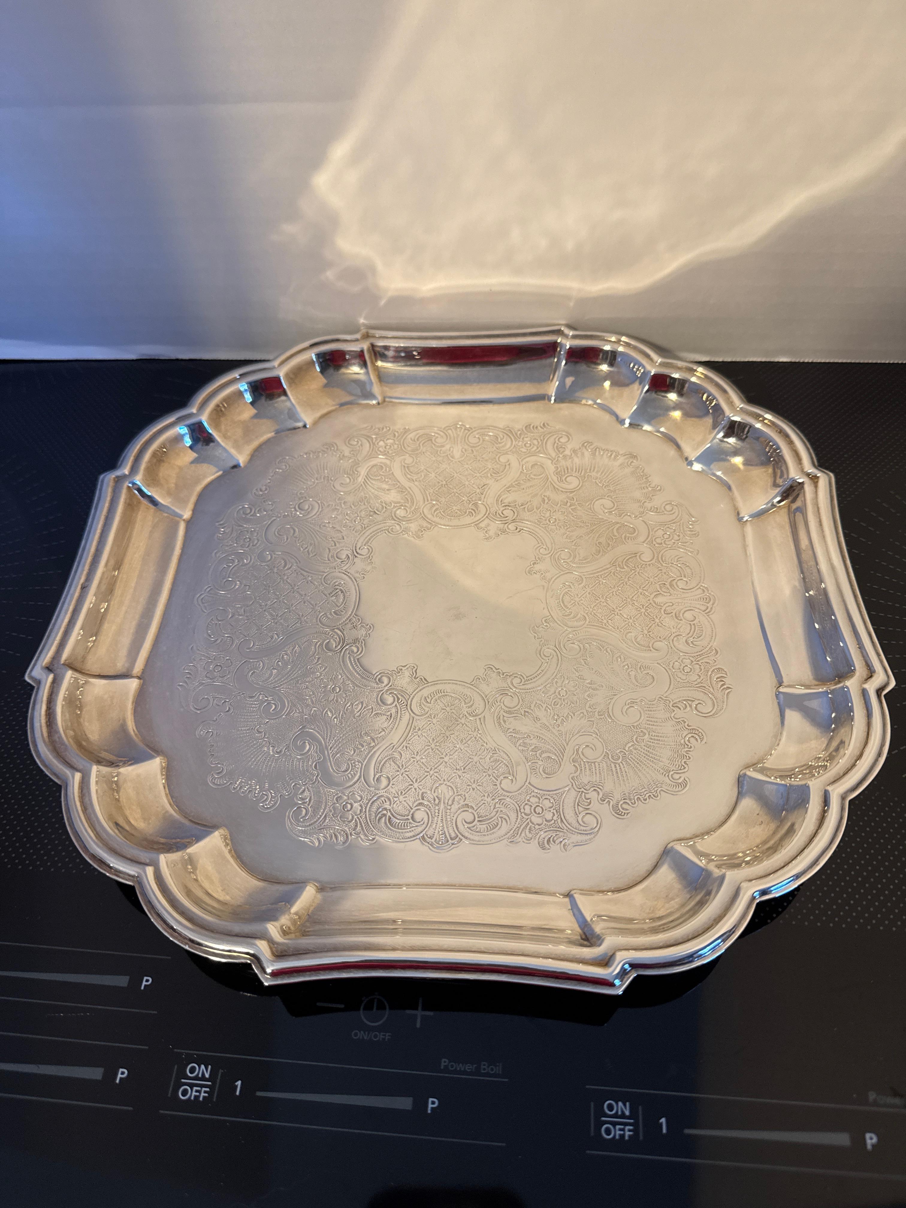 Plateau de service vintage carré en métal argenté, d'occasion, avec un motif orné au centre.  Il ajoutera de la classe à tout service de thé