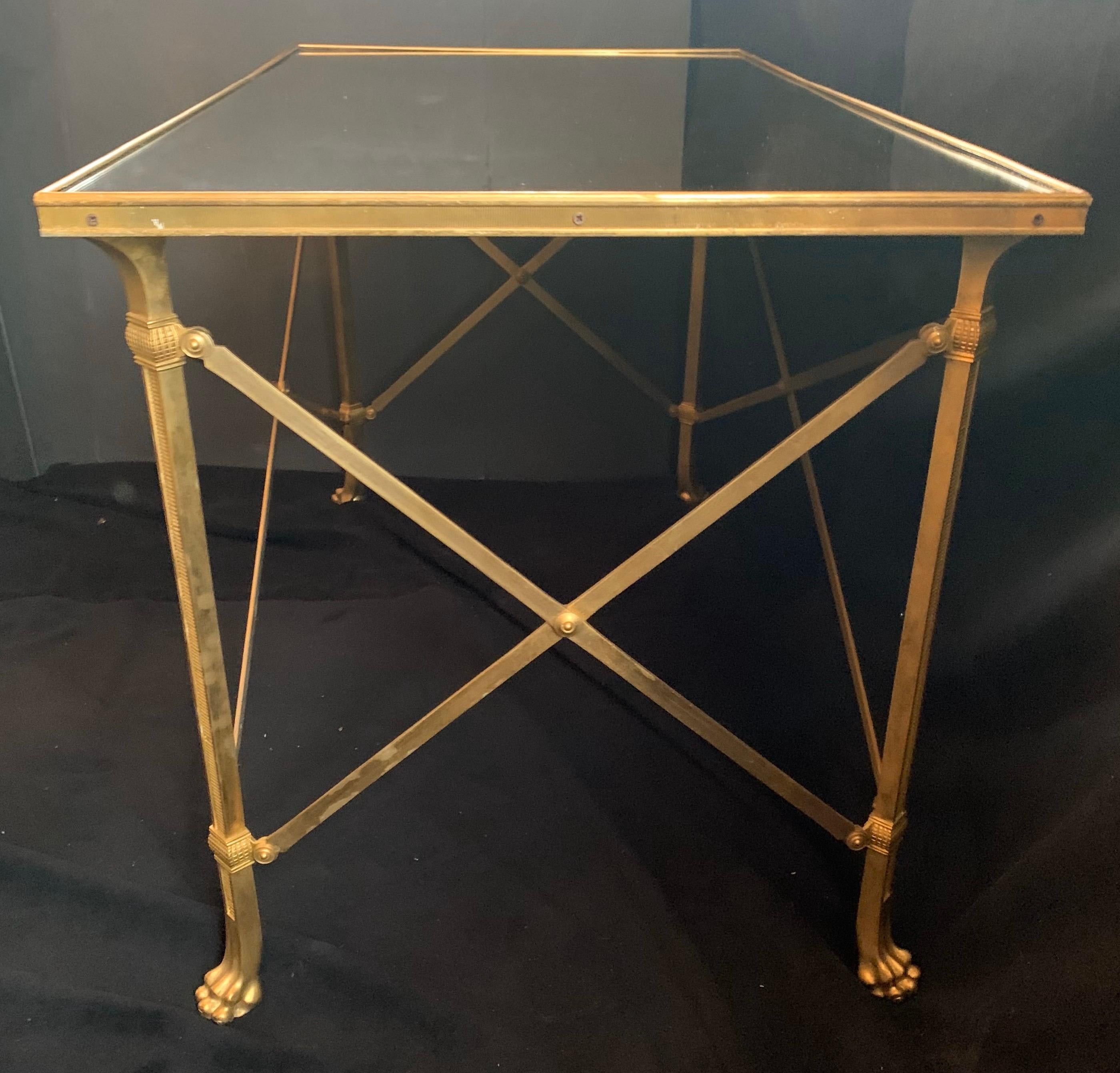 A wonderful Regency style French ormolu bronze and antiqued distressed mirrored top gueridon side / coffee table with paw feet retailed by The Lorin Marsh Showroom in the D & D Building NYC.