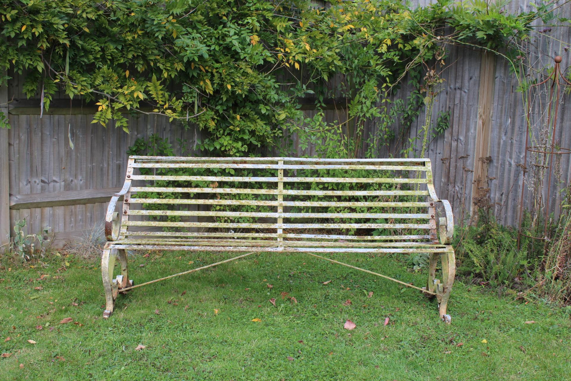 A Regency garden seat of excellent proportions made from wrought or also known as strap iron, the back has a graceful sloping shape with the scroll arms with a rare double scroll in between each of the end legs, these are rare to find like this and