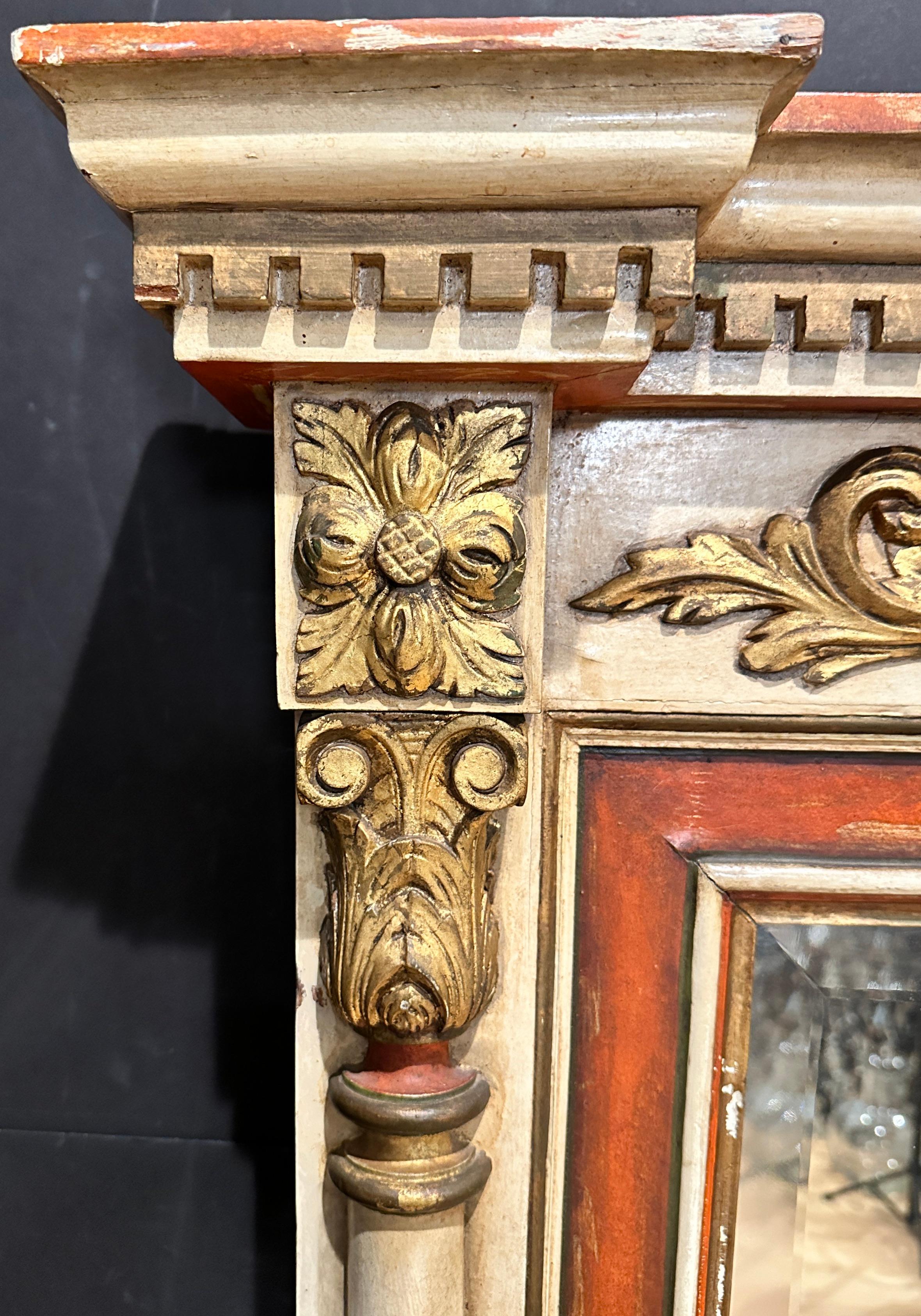 Large paint ant gilt mirror in the Regency style, Italian circa 1900. Off white ground with terracotta and gilt accents. Dental detail across the top molding with acanthus leaves and swag details on left and right fluted and tapered columns.