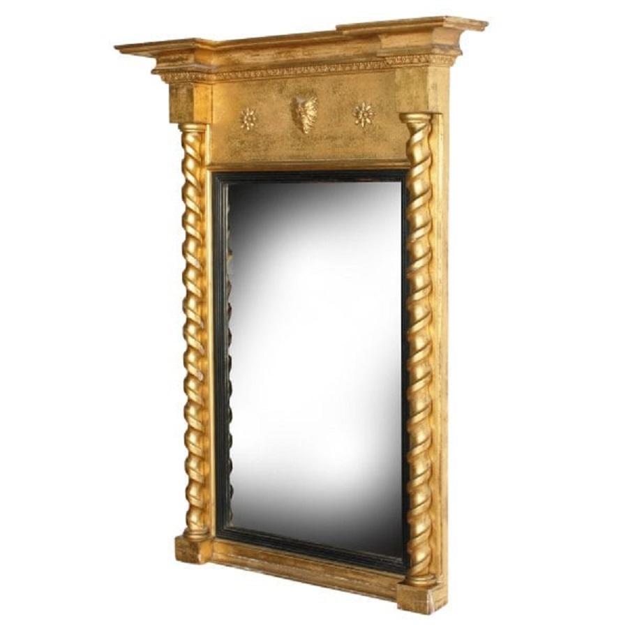 An early 19th century Regency gilt wood pier glass.

The mirror plate has a bevel edge and surrounded by an ebonised wood slip that has a reeded detail.

The gilt wood frame has a break back overhanging cornice with a double moulded edge and