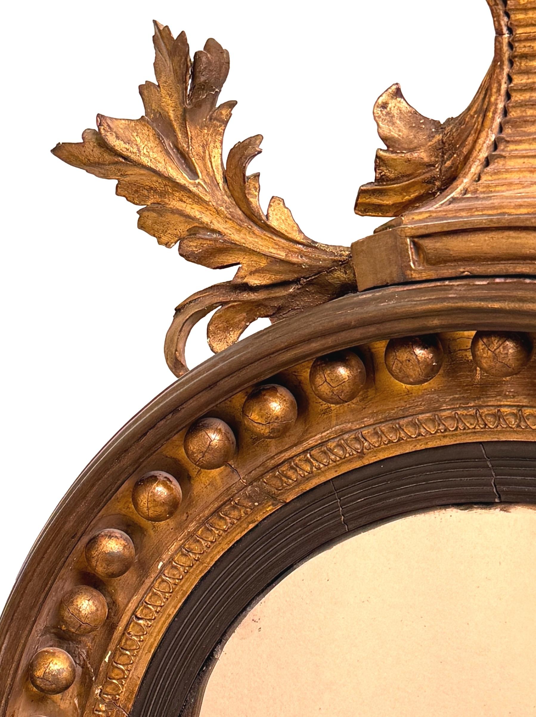 Charmant miroir convexe circulaire en bois doré et gesso de la période Regency, de belles proportions, avec un aigle superbement sculpté surmontant le cadre, avec une surface dorée d'origine et une bordure en forme de boule appliquée, entourant la