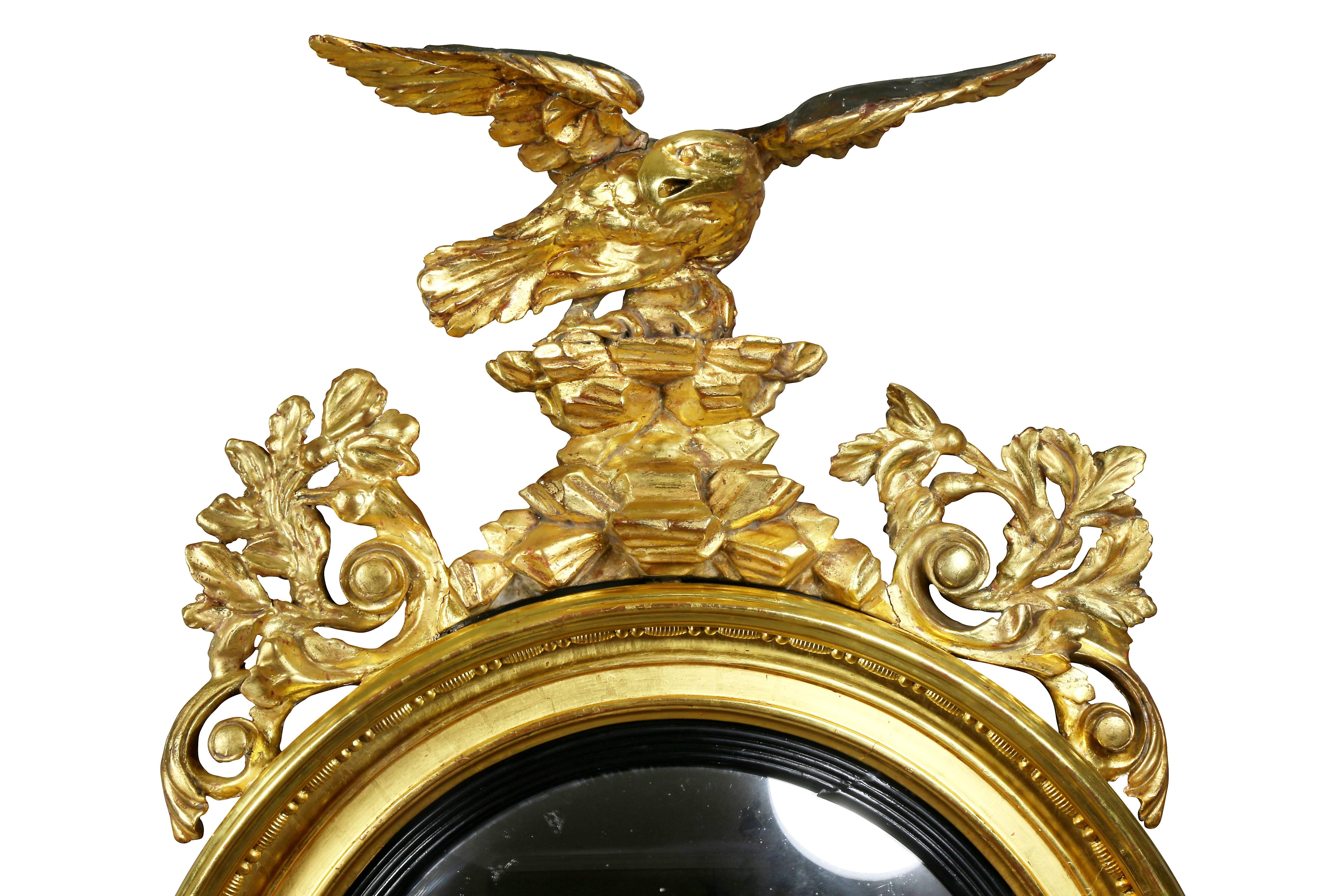 With eagle finial over rockwork flanked by arabesque carving over a convex mirror plate and four candlearms, below a central sunflower flanked by acanthus leaves.
