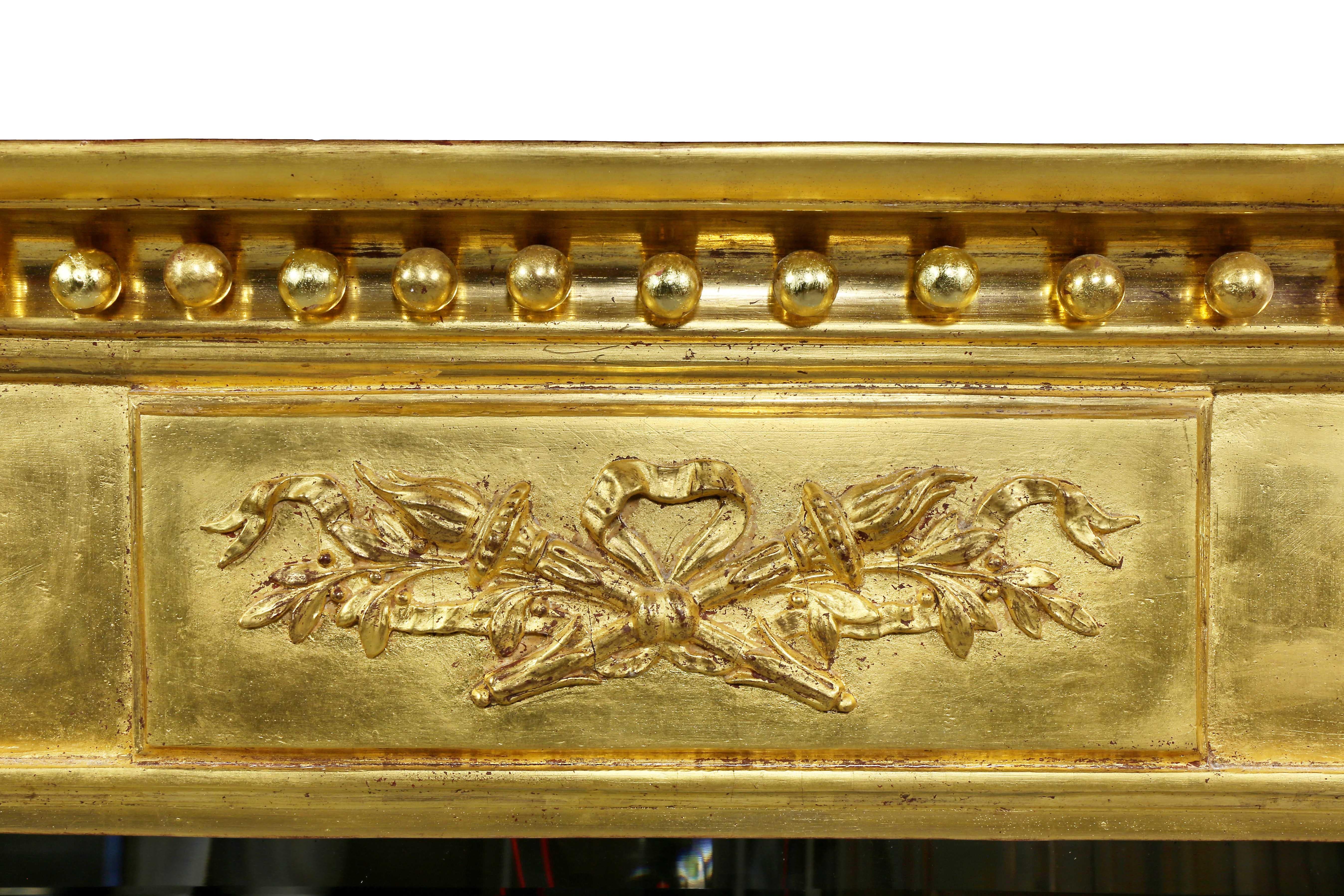 Rectangular with overhanging cornice with gilded sperules over a decorated panel and mirror plate flanked by columns.