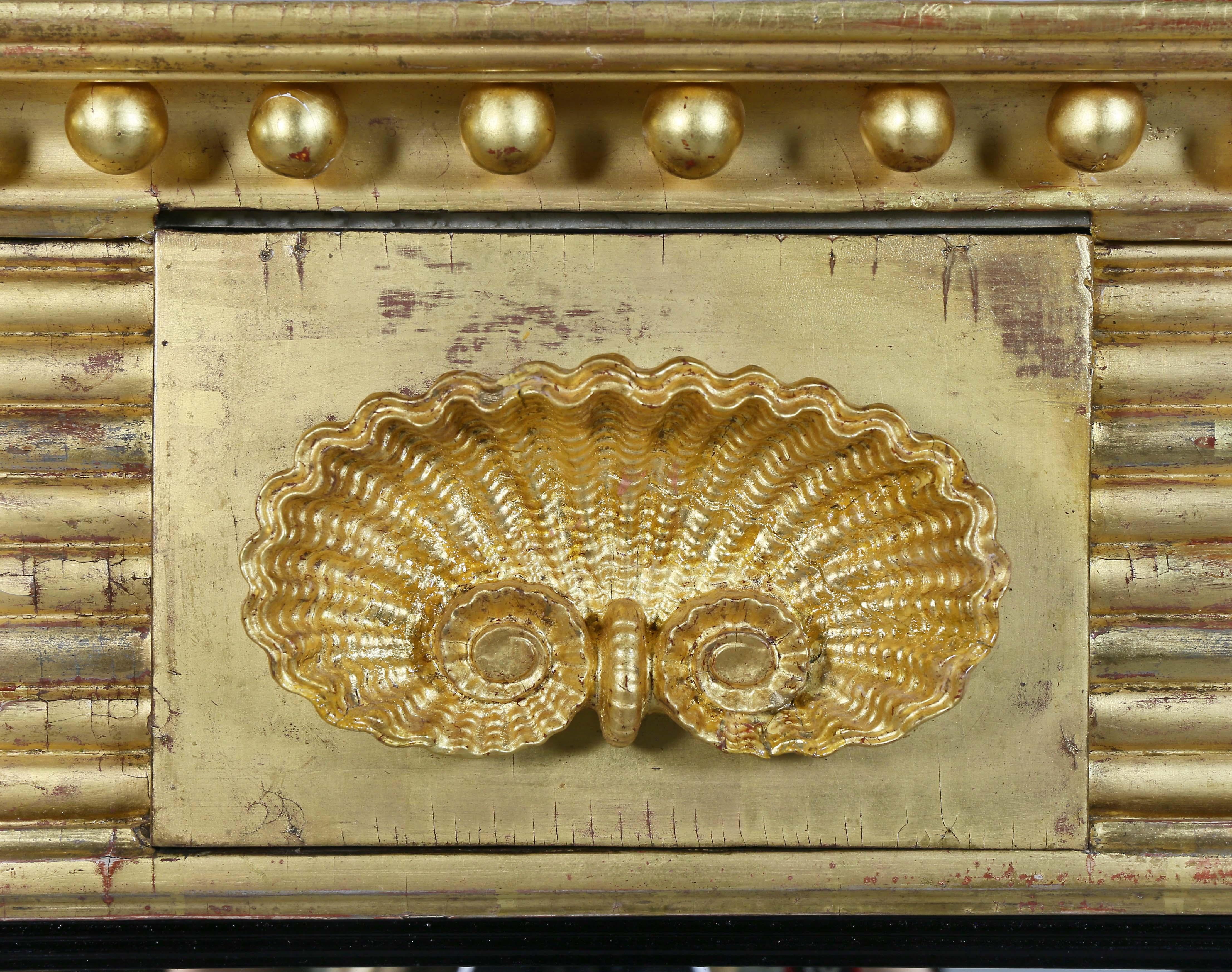 Cornice with sperules over a central shell and flanked by horizontal reeded decoration, the mirror with ebonized wood outer band flanked by rope twist columns.