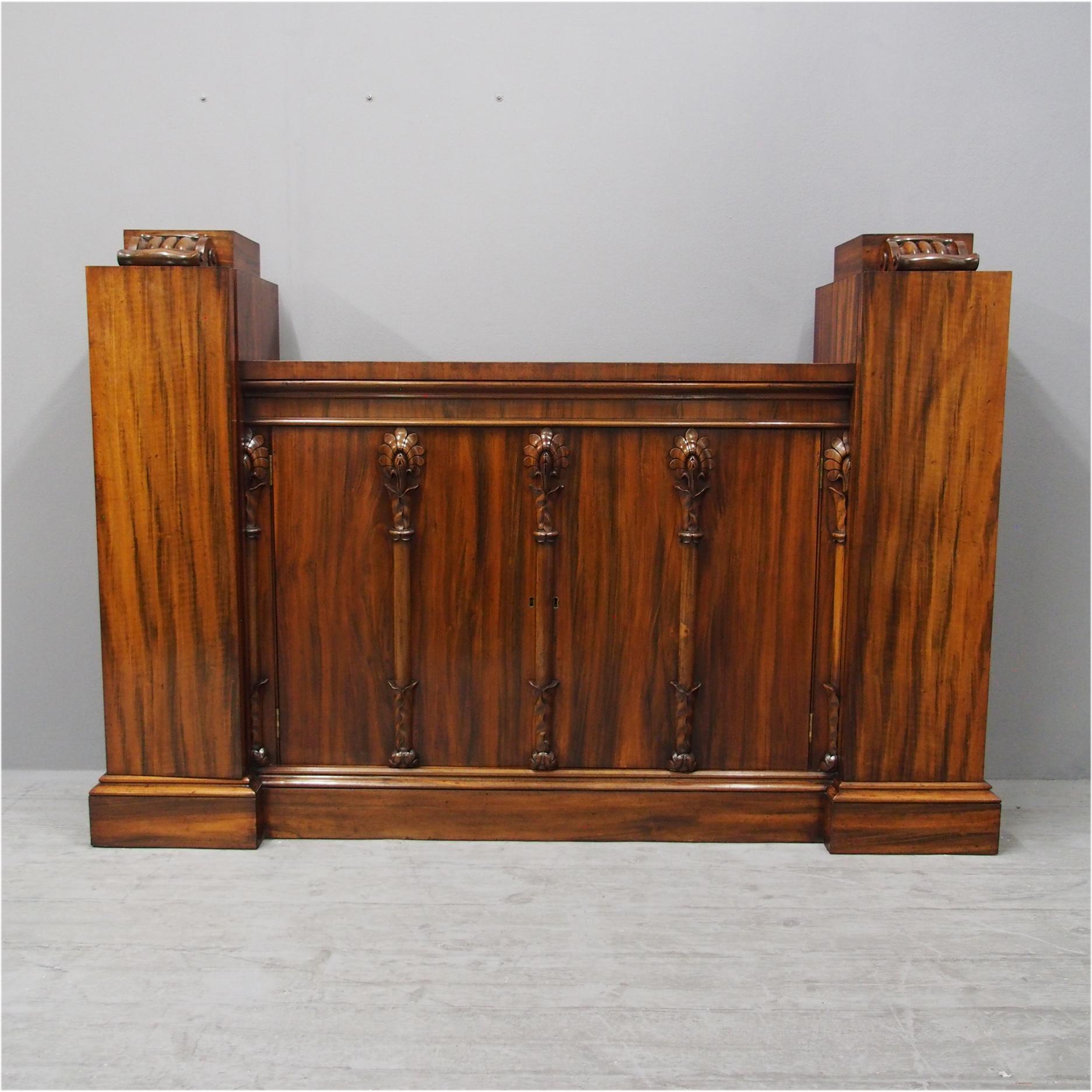 Rare Regency, goncalo alves (tigerwood) side cabinet, circa 1830. With raised side cupboards surmounted by carved foliate mounted plinths opening to fitted interiors. The lower central section has a well figured top, moulded fore-edge over twin