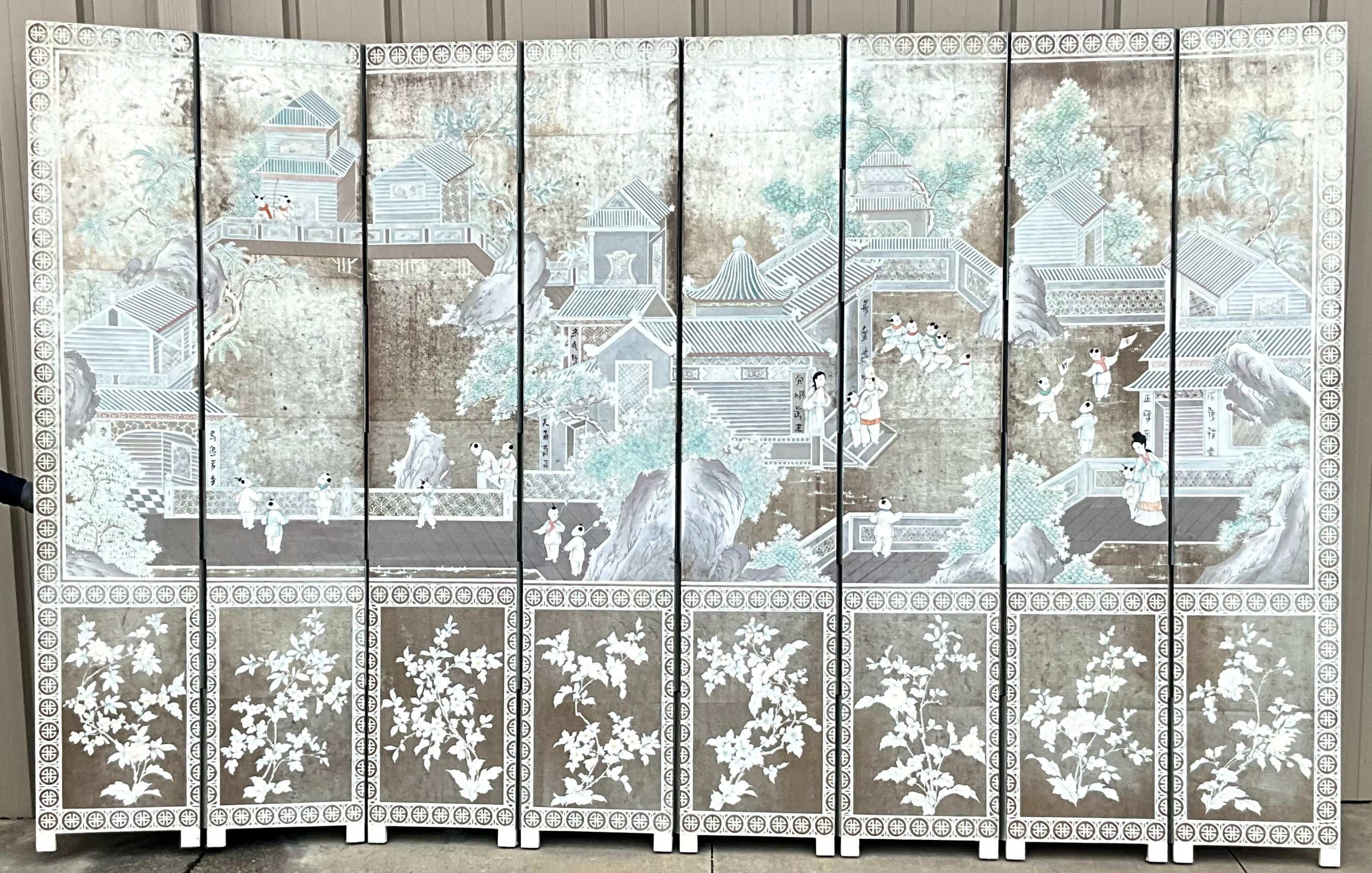 I love this screen! It is monumental in scale with eight panels reaching 94 inches in height. It is hand painted chinoiserie scenes on silver foil paper reminiscent of the lovely works by Gracie. The front is in very good condition, while the back